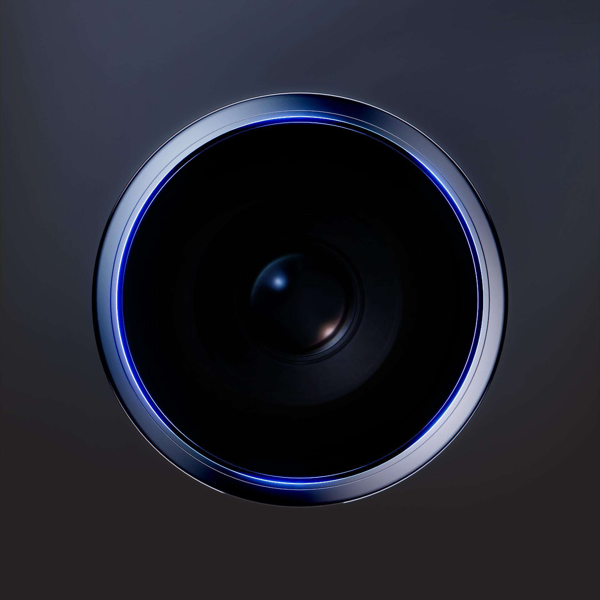 Zbliżenie ciemnej soczewki z niebieskim świecącym pierścieniem na ciemnoszarym tle.