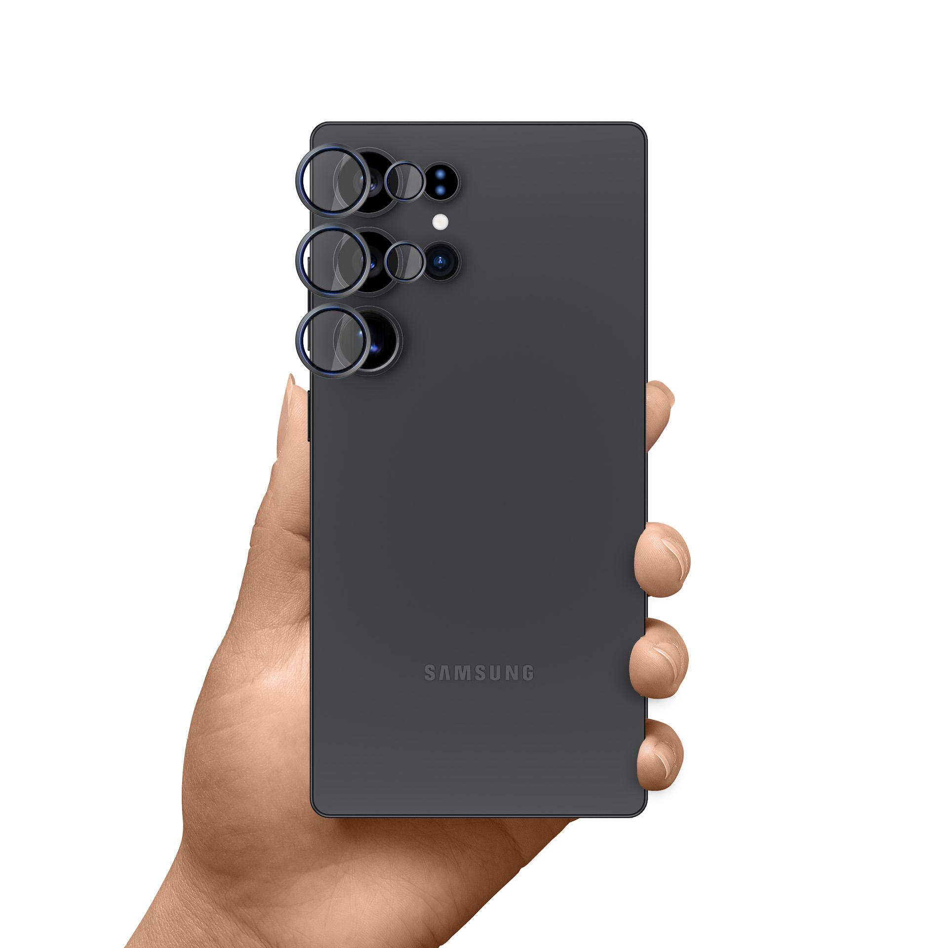 Una mano che tiene un telefono Samsung grigio. La parte posteriore del telefono ha più lenti della fotocamera. Sfondo bianco.