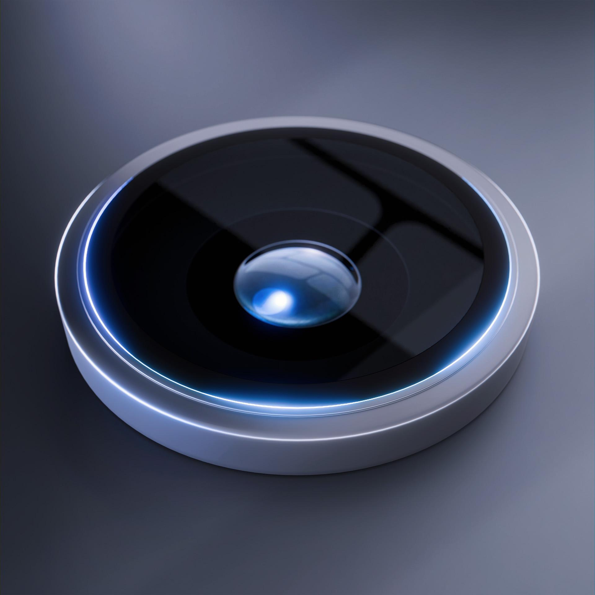 Primo piano di un obiettivo nero e argento. Una luce blu illumina il bordo e il centro.