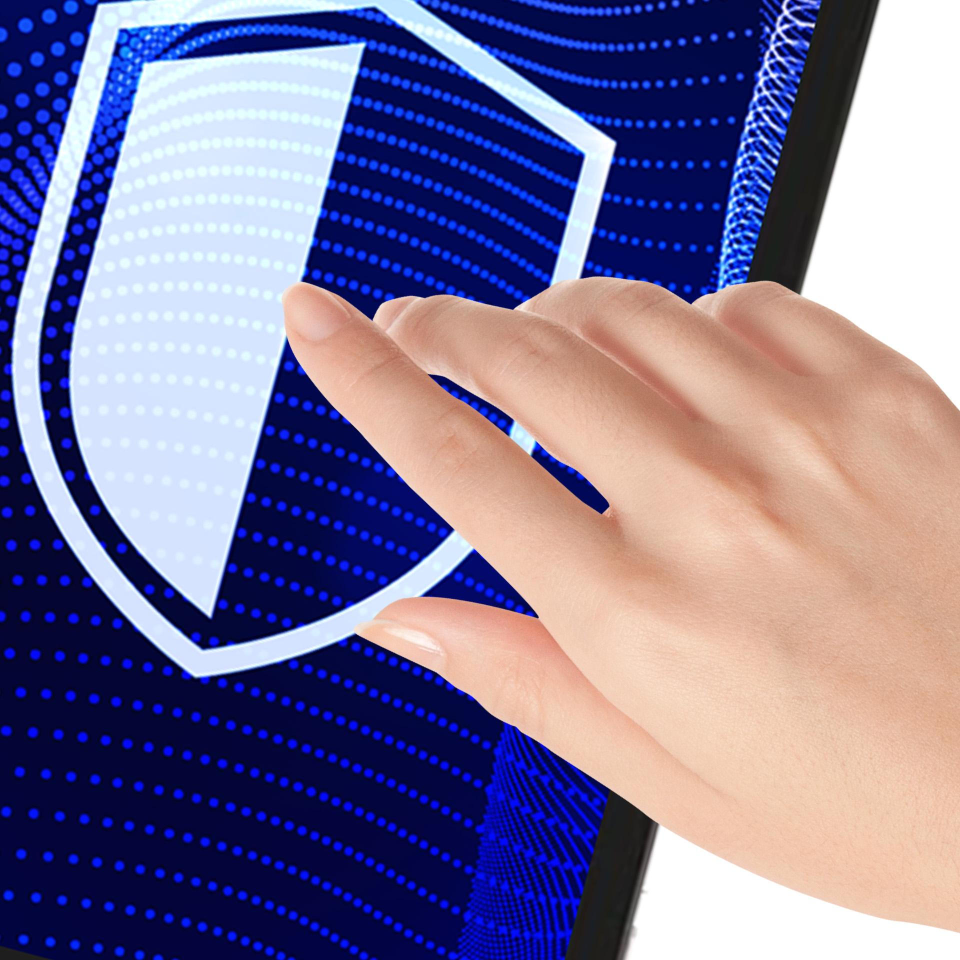 Dłoń dotyka ekranu tabletu z ikoną tarczy na niebieskim, kropkowanym tle.