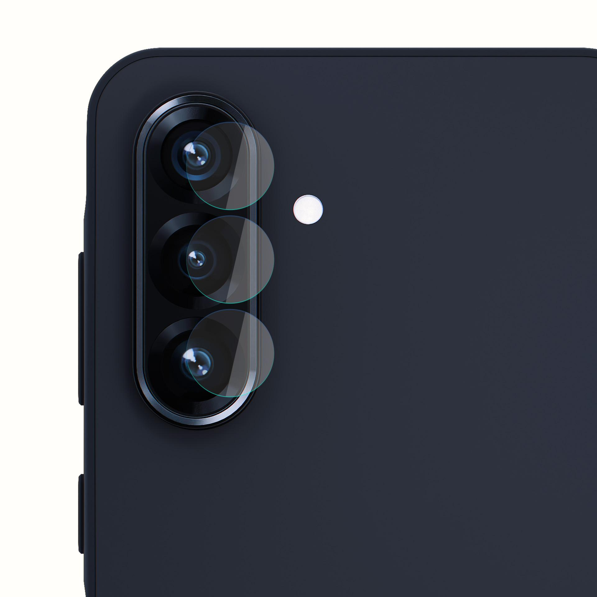 Primo piano di un modulo fotocamera del telefono con tre lenti protette da coperture trasparenti. Il telefono è blu scuro.