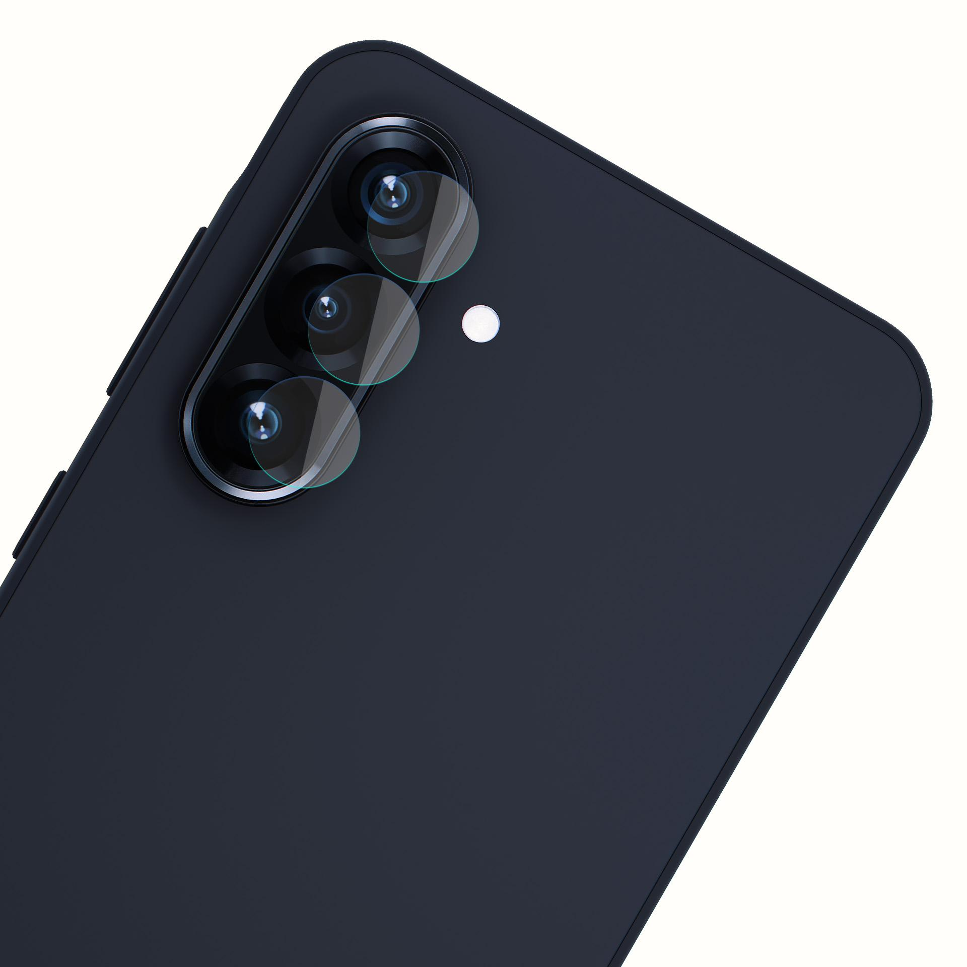 Retro di smartphone blu scuro con tre obiettivi e un punto bianco, angolato su sfondo bianco.
