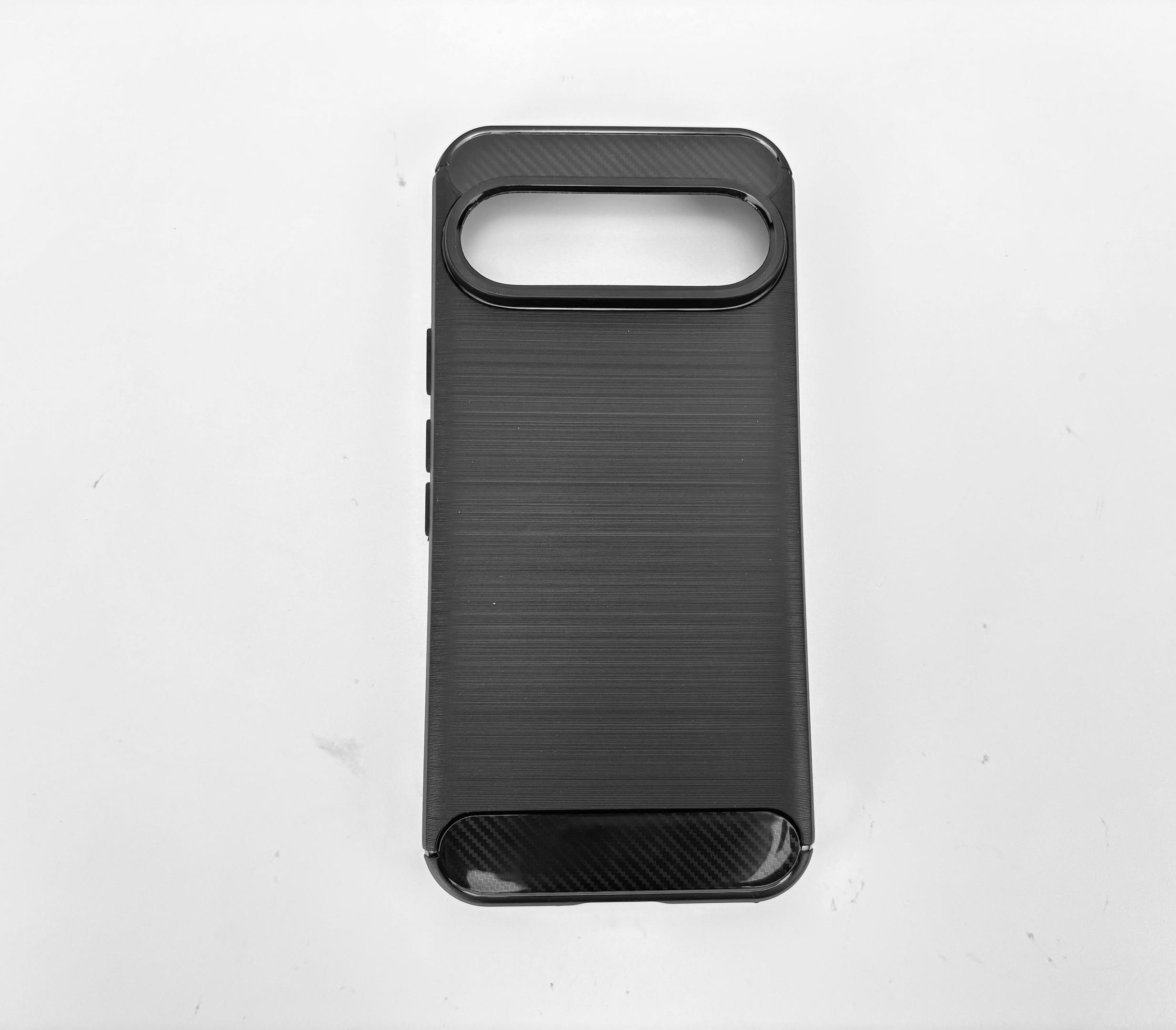 Una custodia nera per telefono su una superficie bianca. Ha un ritaglio per la fotocamera e un retro strutturato.