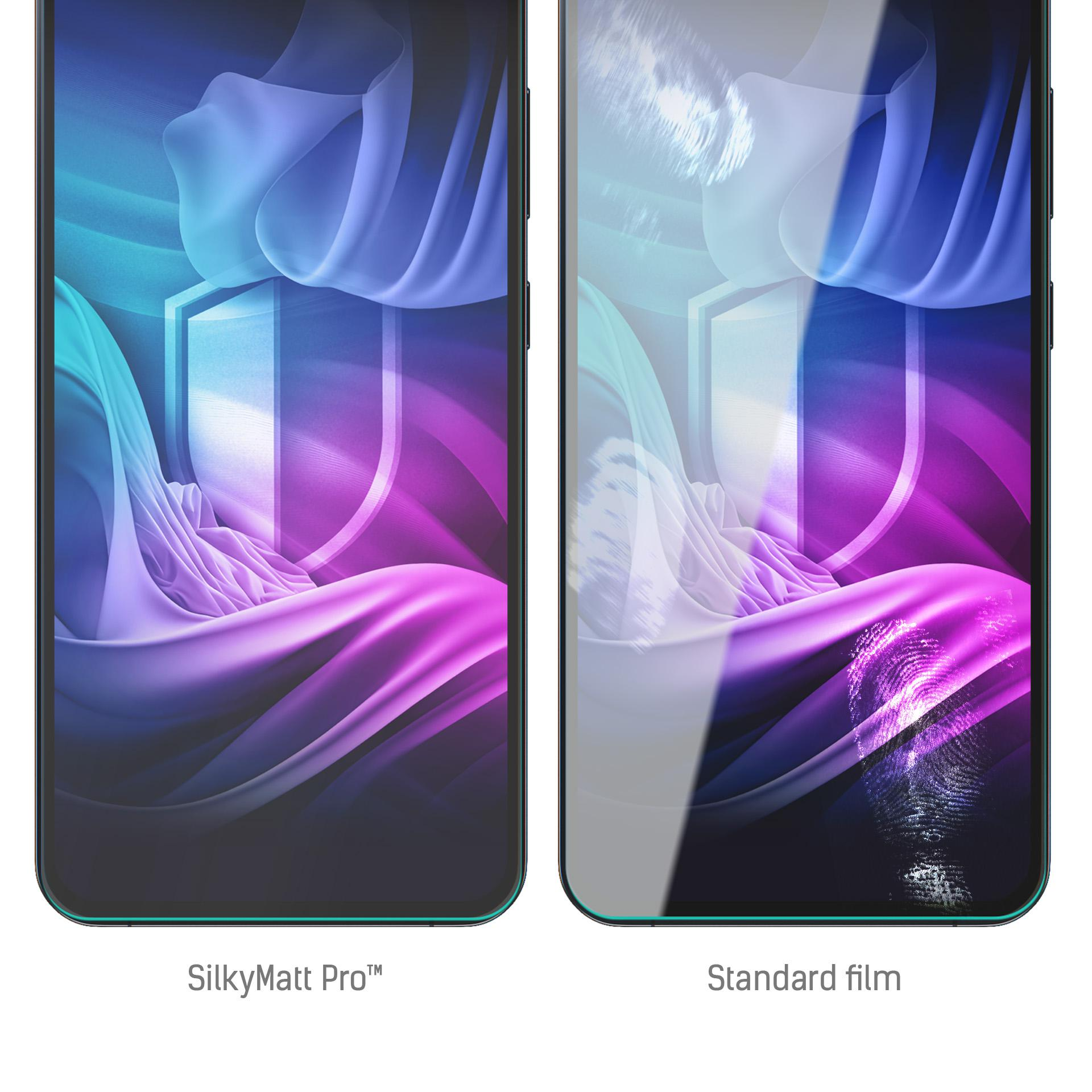 Due telefoni affiancati. Uno ha SilkyMatt Pro, l'altro pellicola standard. Sfondo astratto blu, viola e bianco.