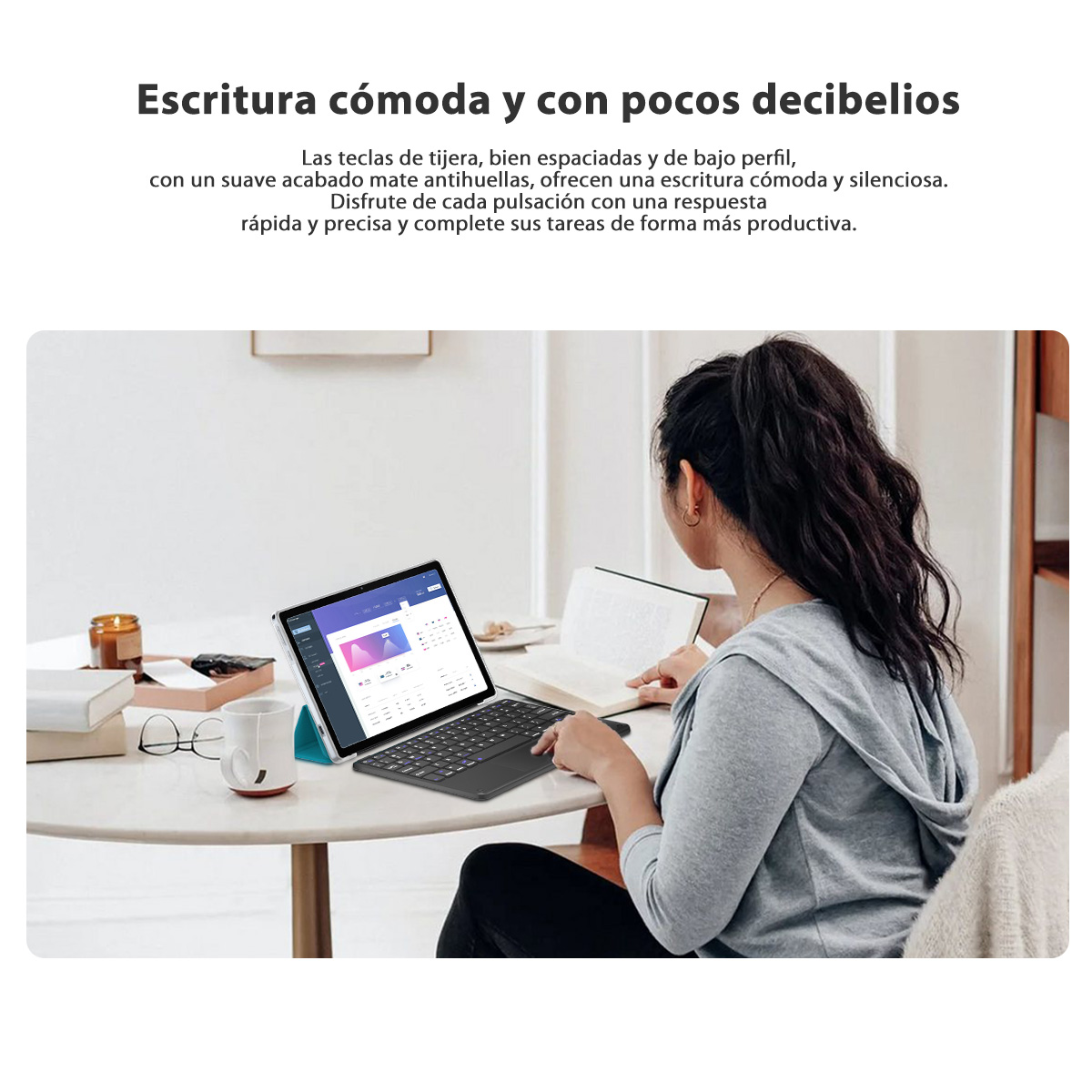 Una mujer usa una tableta con teclado en una mesa. Una taza, libros y una vela también están en la mesa.
