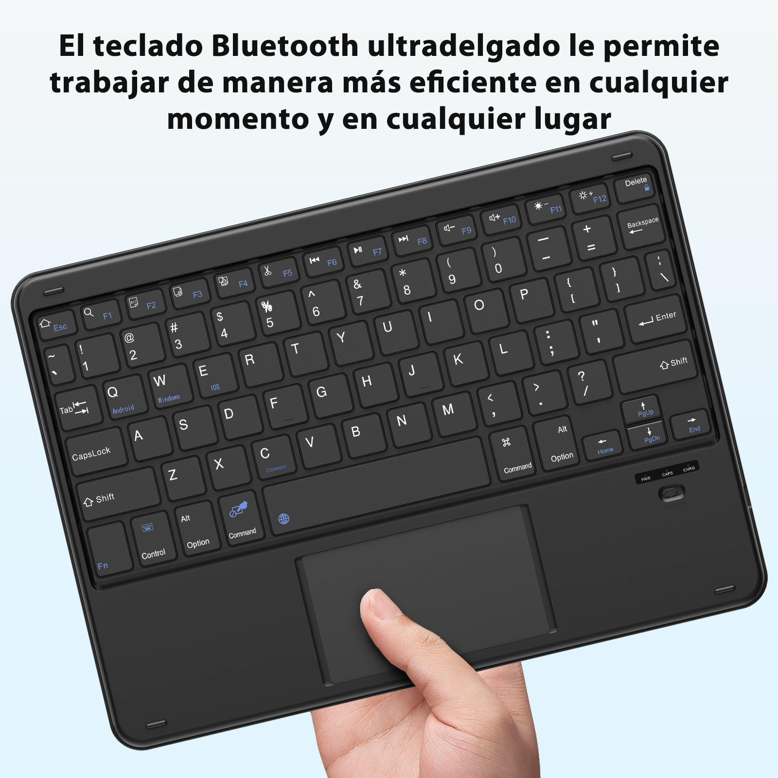 Teclado Bluetooth negro con panel táctil. Una mano lo sostiene. Teclas etiquetadas.