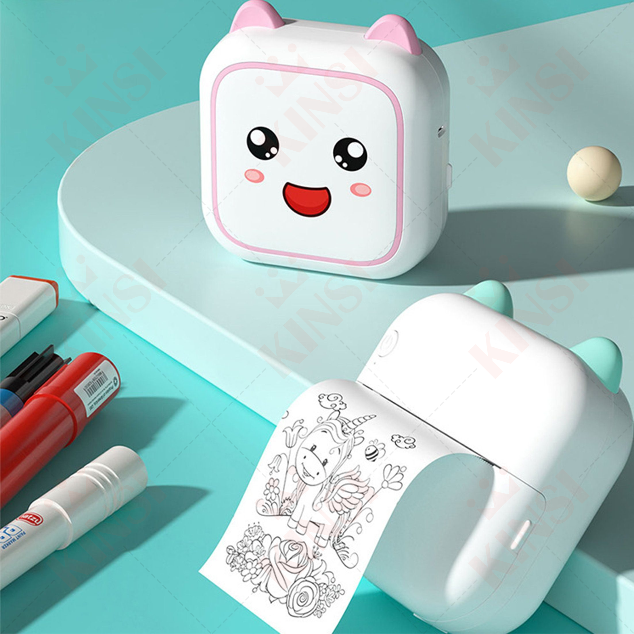 Ein weißer Drucker mit rosa Ohren und einem lächelnden Gesicht, ein zweiter mit grünen Ohren. Malvorlagen und Marker liegen daneben.