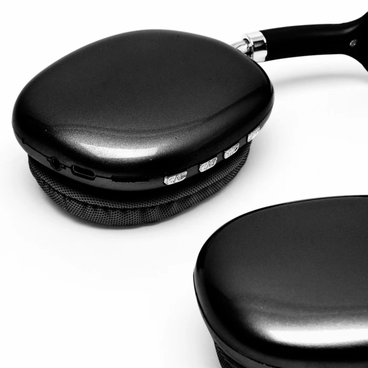 Primer plano de auriculares negros sobre fondo blanco. Detalles incluyen auriculares con botones y diadema.