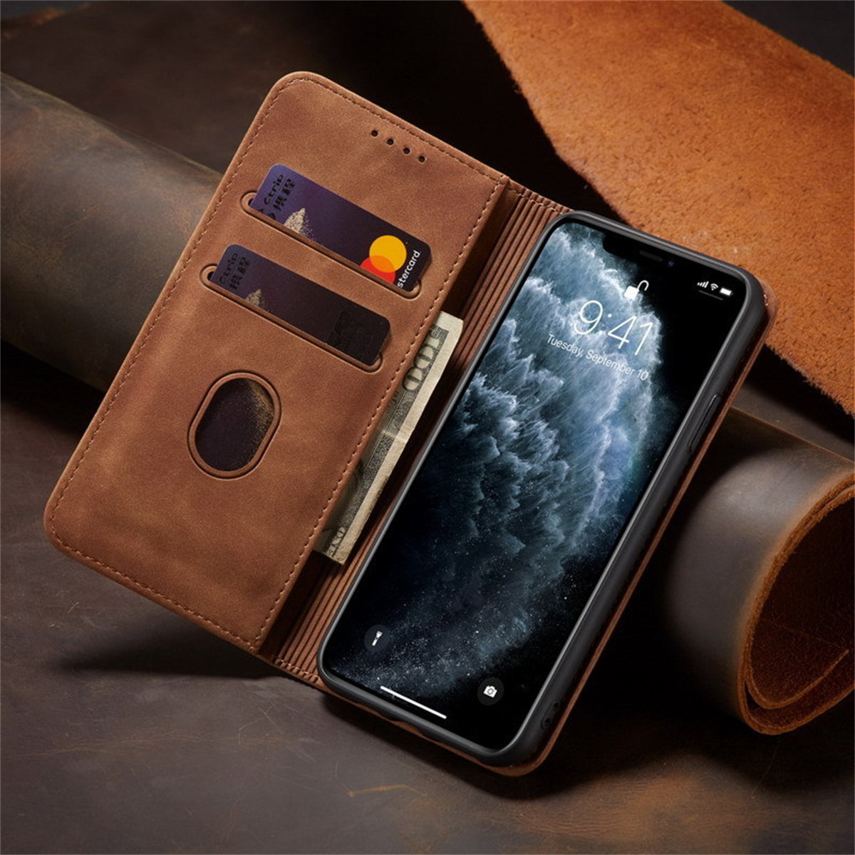 Braune Leder-Handyhülle mit Karten und Bargeld. Ein iPhone zeigt die Uhrzeit. Der Hintergrund ist ebenfalls braunes Leder.