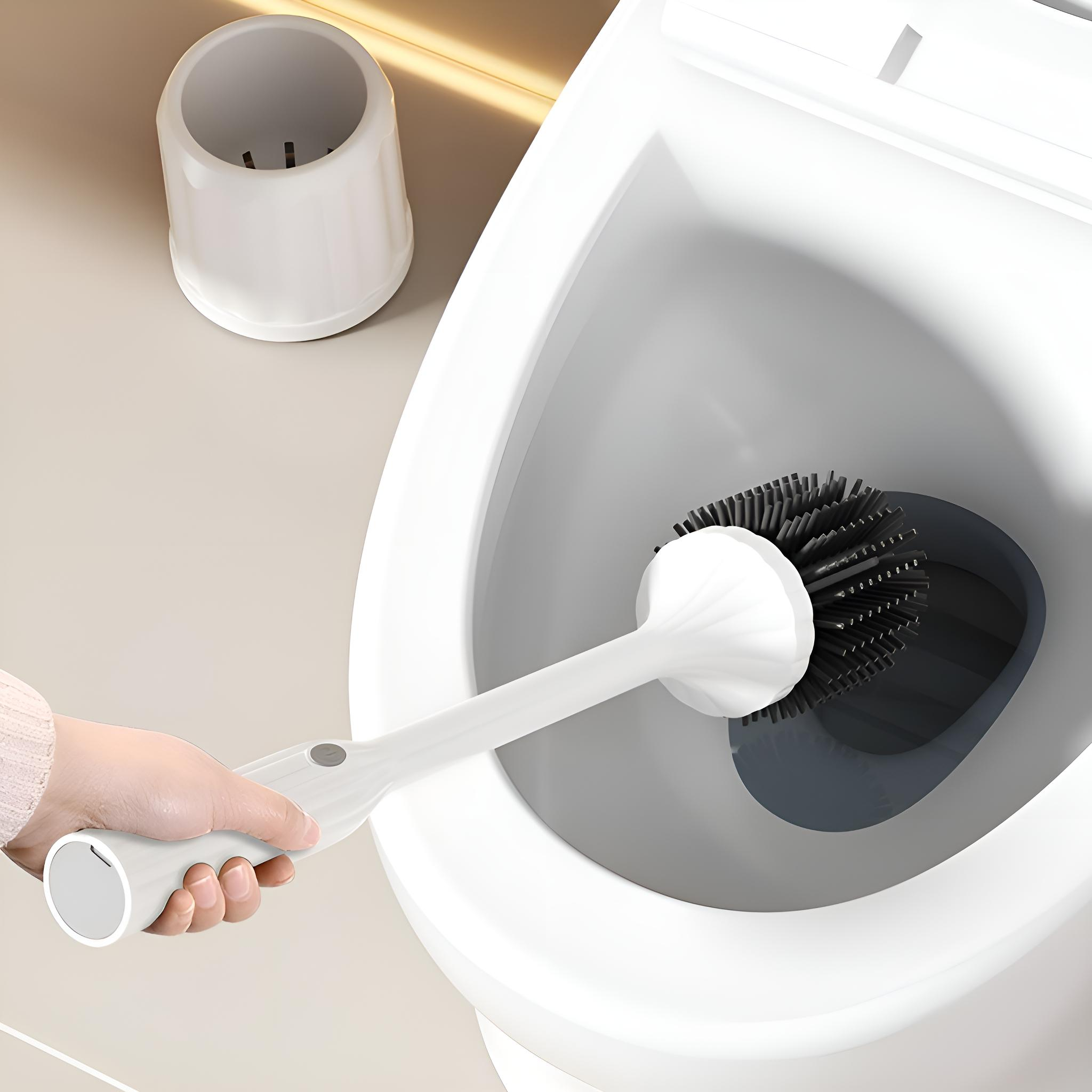 Eine Hand hält eine weiße Toilettenbürste über einer weißen Toilettenschüssel. Ein weißer Halter steht daneben.