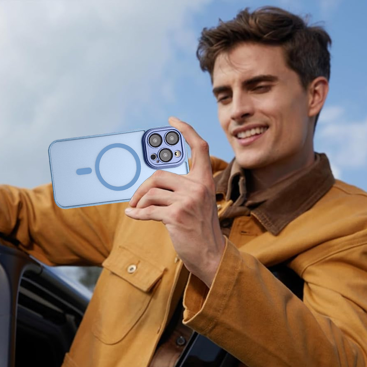 Ein Mann hält ein Telefon mit einer blauen Hülle und lächelt. Er trägt eine gelbe Jacke. Der Hintergrund ist ein blauer Himmel.