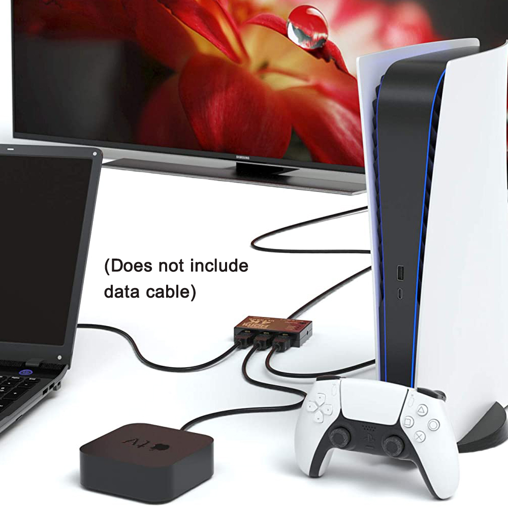 Eine PS5-Konsole, ein Controller und Apple TV sind mit einem Fernseher verbunden. Ein Laptop befindet sich links. Kabel sind sichtbar.