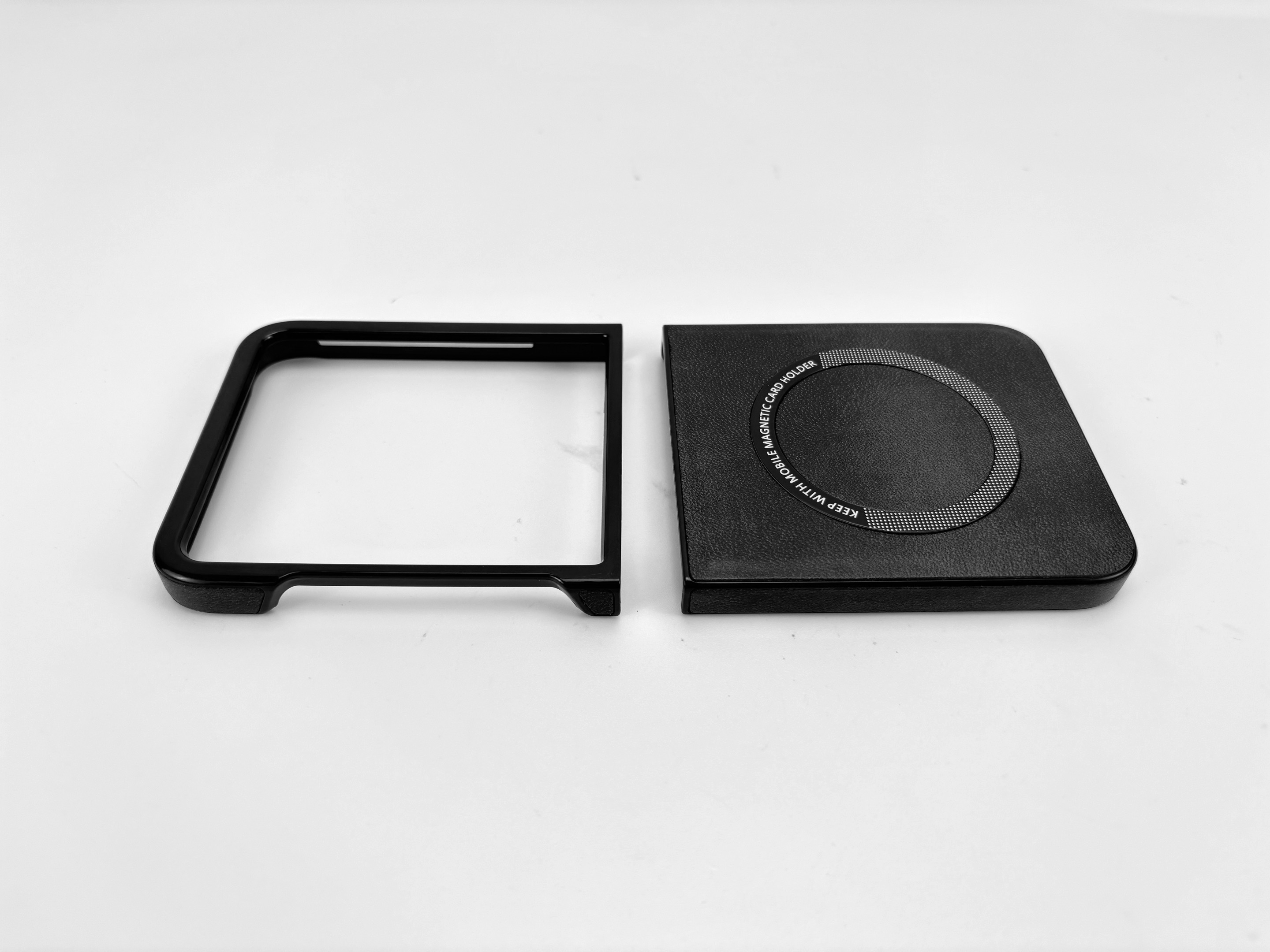 Zwei schwarze Objekte auf weißem Untergrund. Eines ist ein Quadrat mit kreisförmigem Design, das andere ein Rahmen.