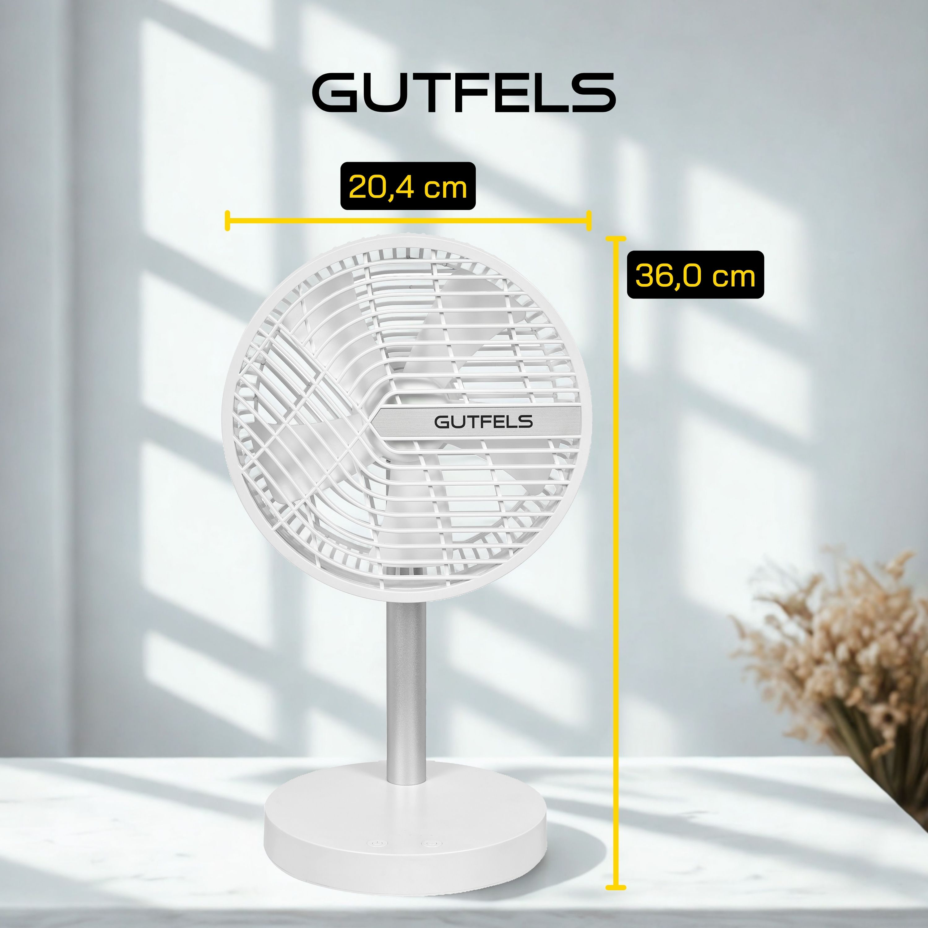 Ventilador eléctrico blanco con base plateada sobre mesa blanca. El ventilador mide 20,4 cm y 36,0 cm. El fondo es blanco.