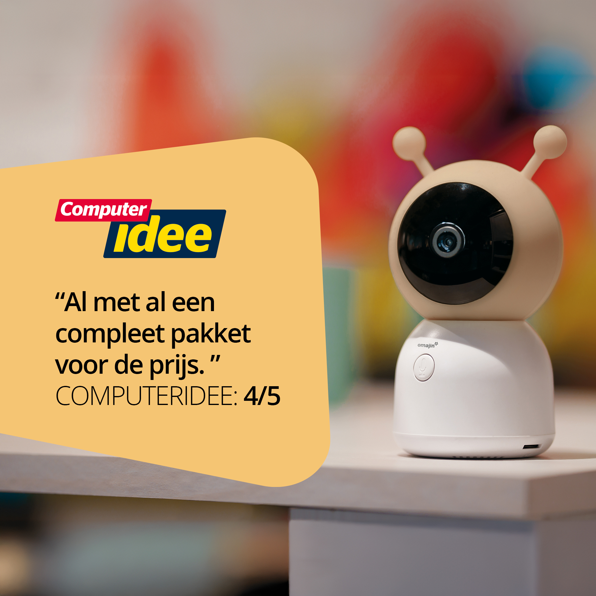 Una telecamera per baby monitor bianca con antenne è su un tavolo di legno. Il testo di una recensione è a sinistra.