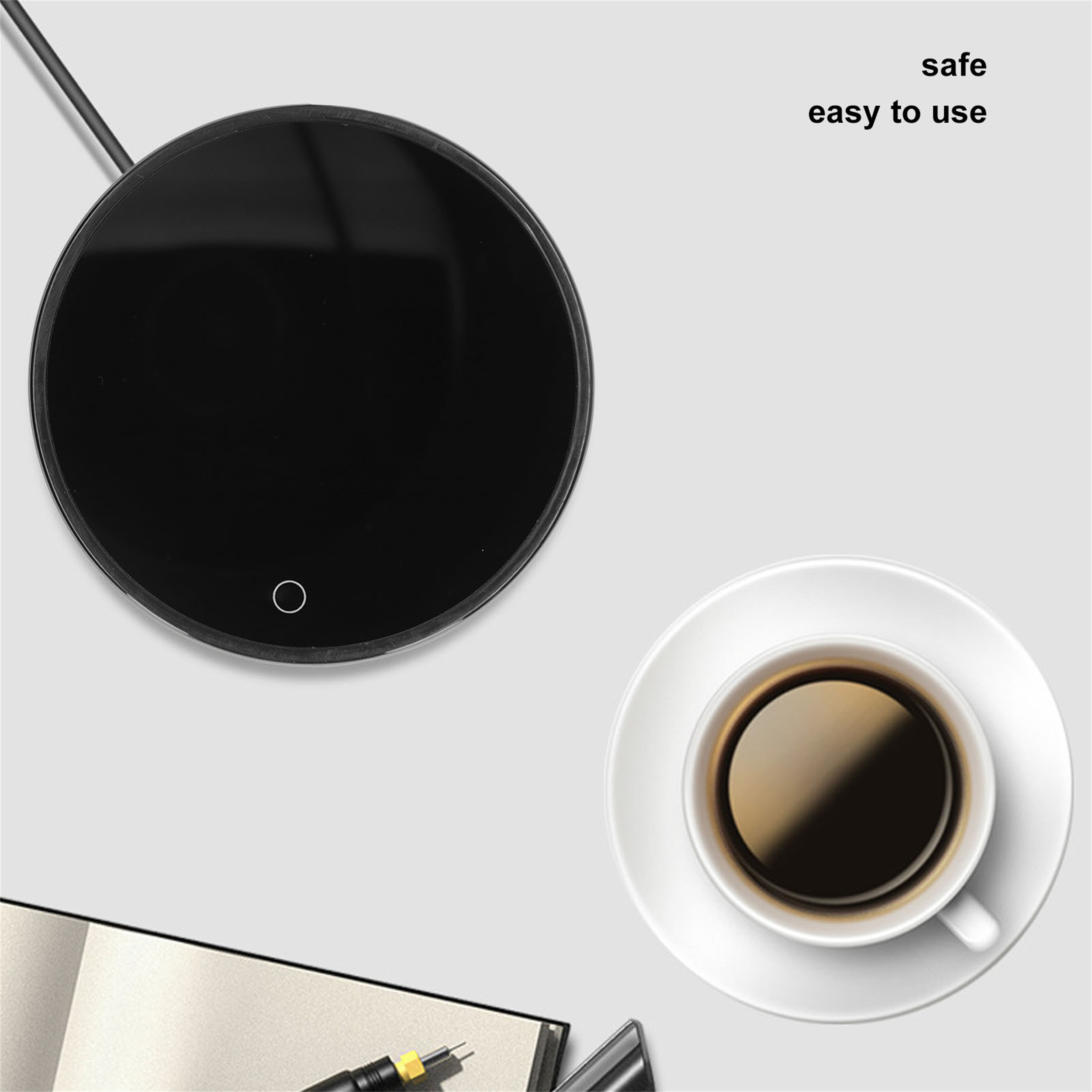 Schwarzer Kaffee-Wärmer und eine Tasse Kaffee auf einer weißen Untertasse. Notizbuch und Stift im Vordergrund.