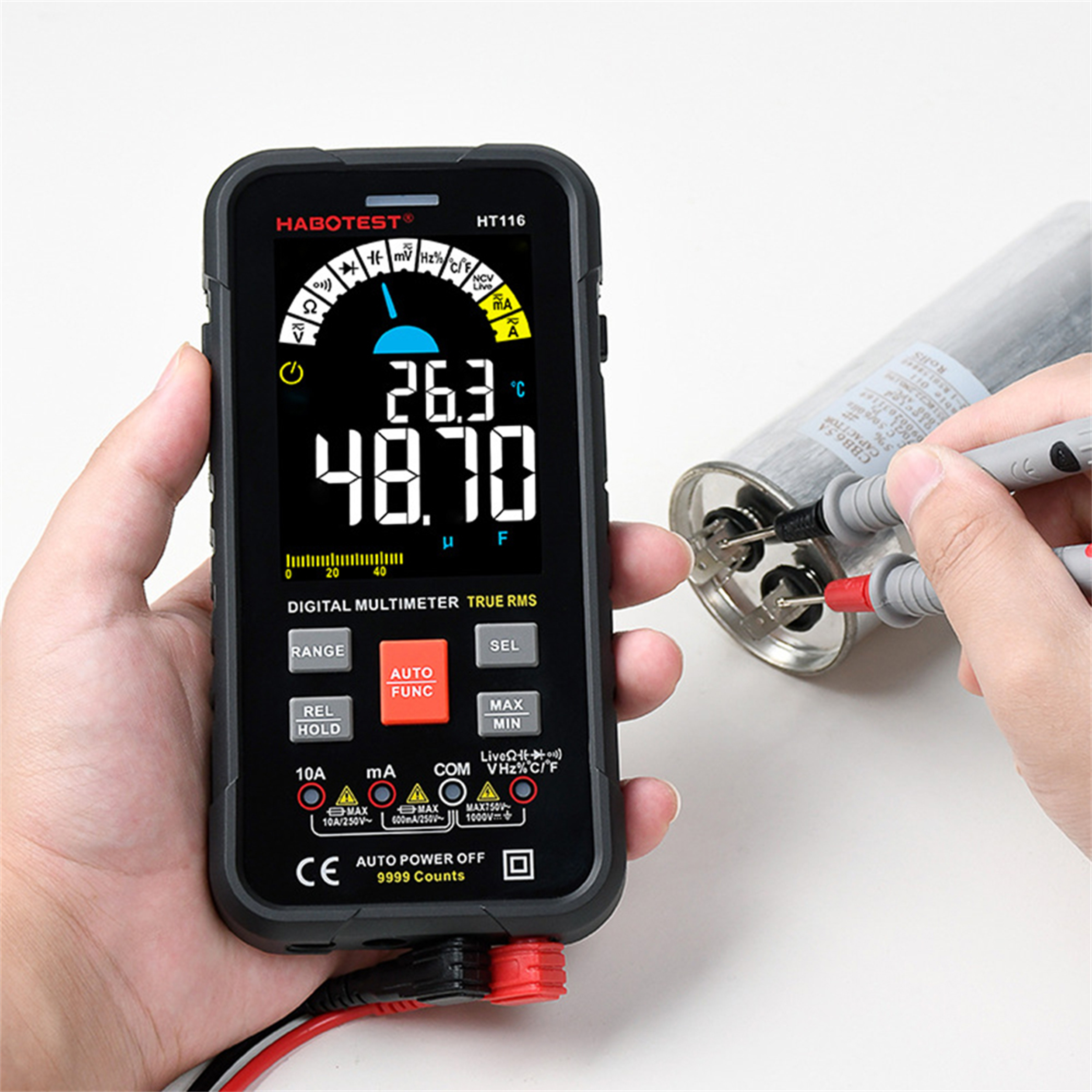Ein digitales Multimeter zeigt 26,3°C und 48,70μF an. Eine Person testet einen Kondensator mit den Sonden.