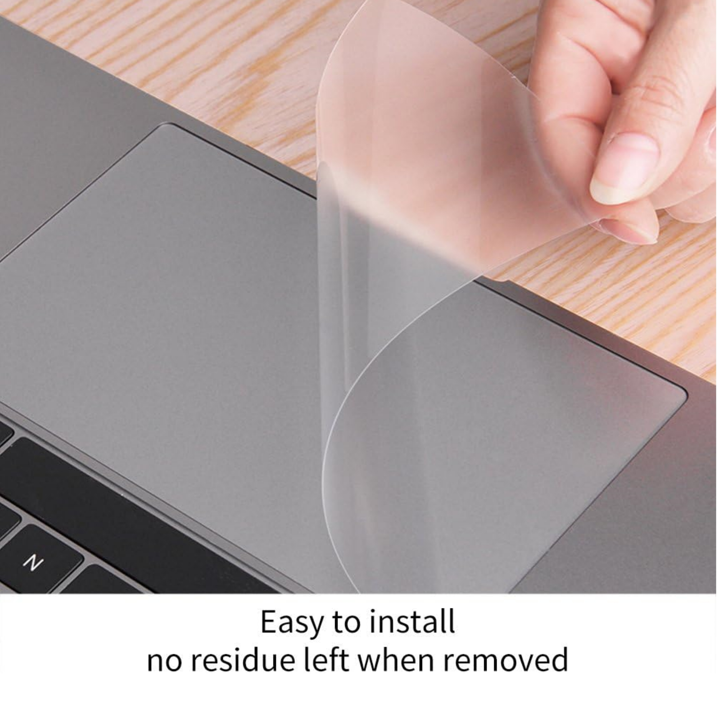 Eine Hand, die eine Schutzfolie von einem Laptop-Touchpad abzieht.