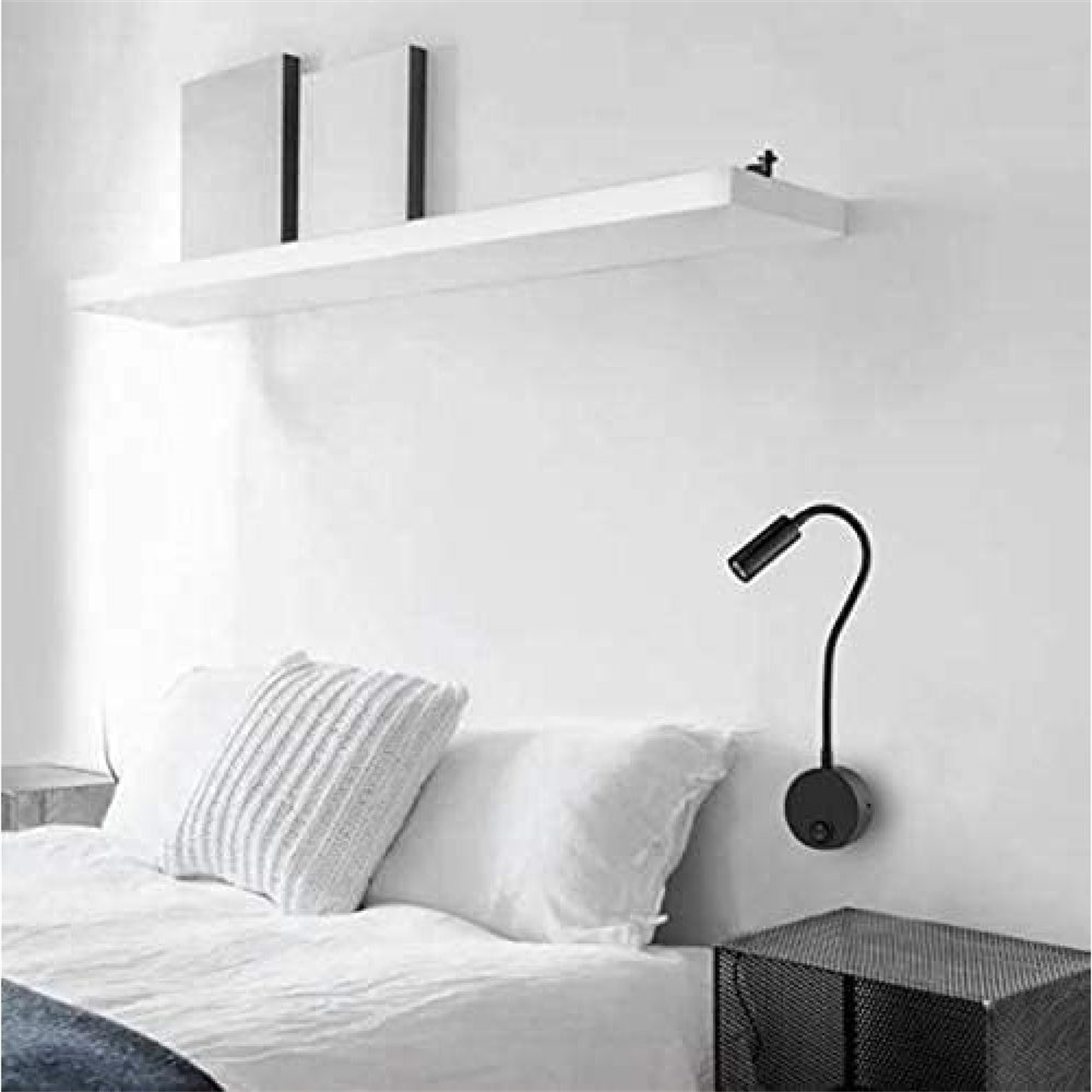Schlafzimmer mit einer Wand-Leselampe. Bett und Regale sind sichtbar.