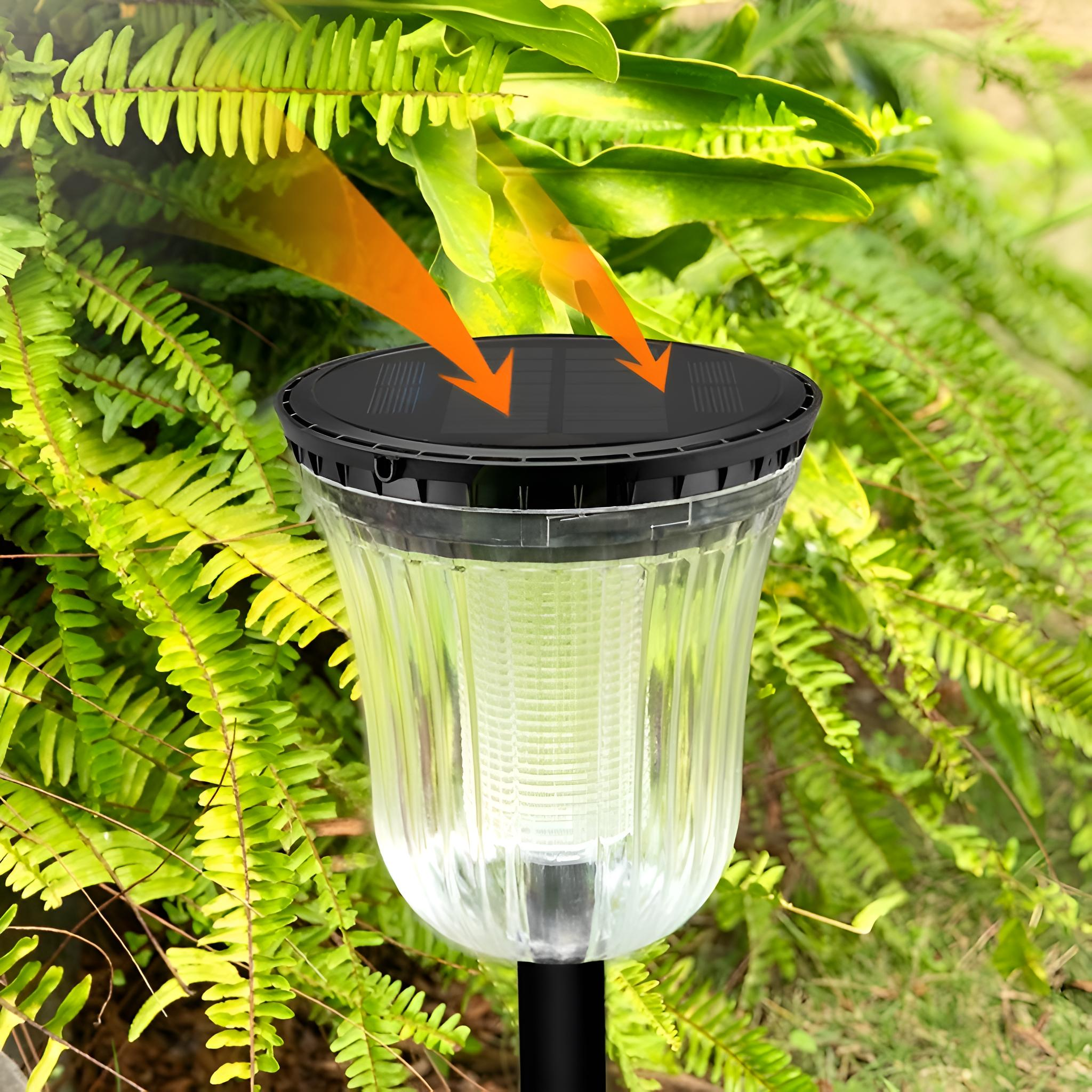 Nahaufnahme der Solar-Gartenleuchte. Wassertropfen auf dem klaren Kunststoff, Sonnenlichtpfeile oben.