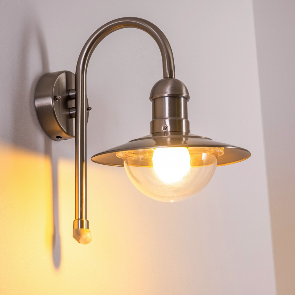 Silberne, an der Wand montierte Außenlampe mit gebogenem Arm und Glasschirm. Helles Licht.