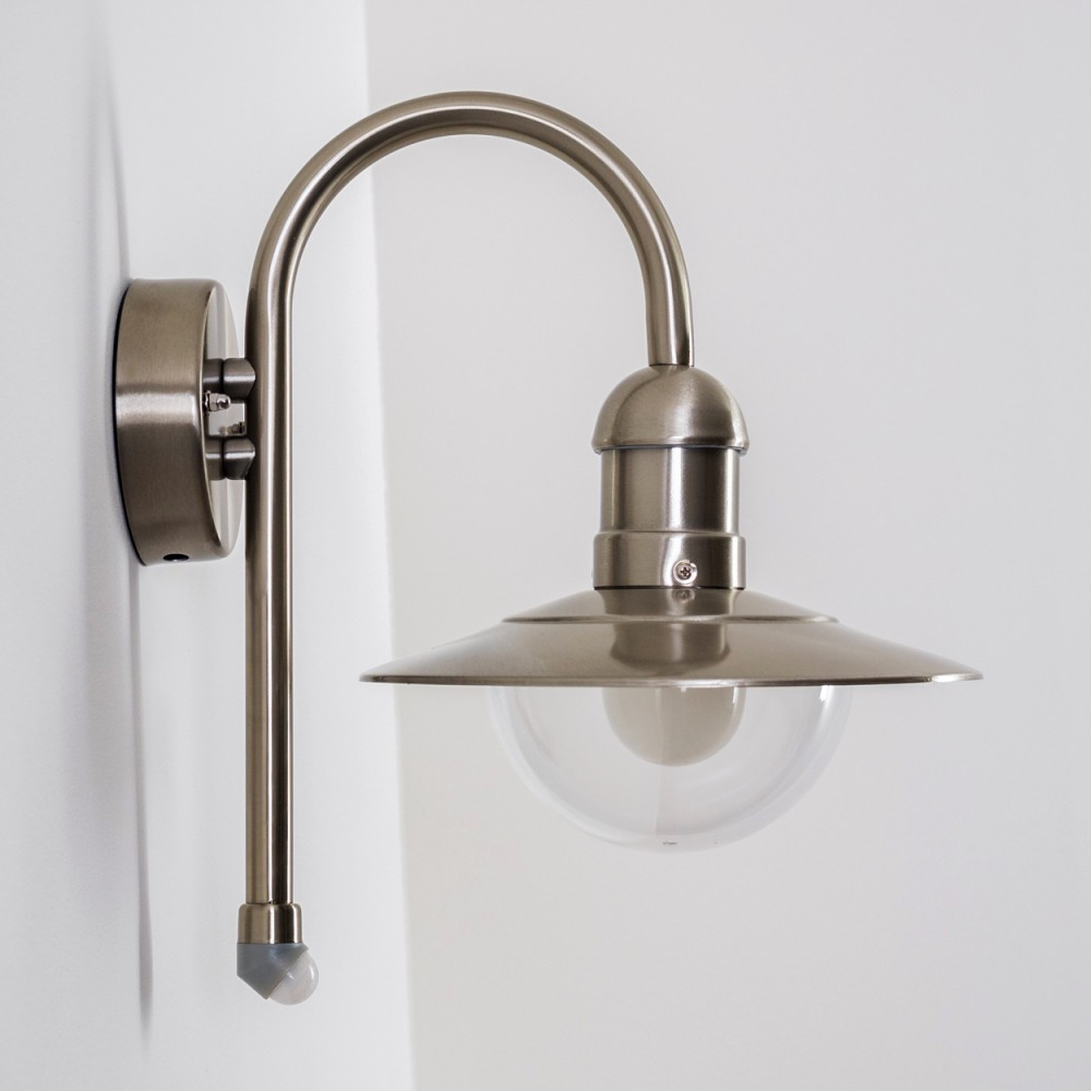 Silberne Außenwandleuchte mit gebogenem Arm und klarem Globus. An einer weißen Wand montiert.