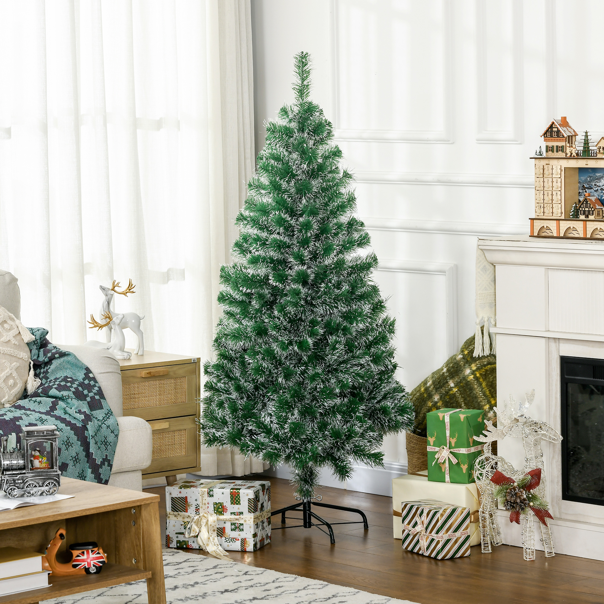 Ein grüner Weihnachtsbaum mit Schnee und Geschenken in einem Wohnzimmer.