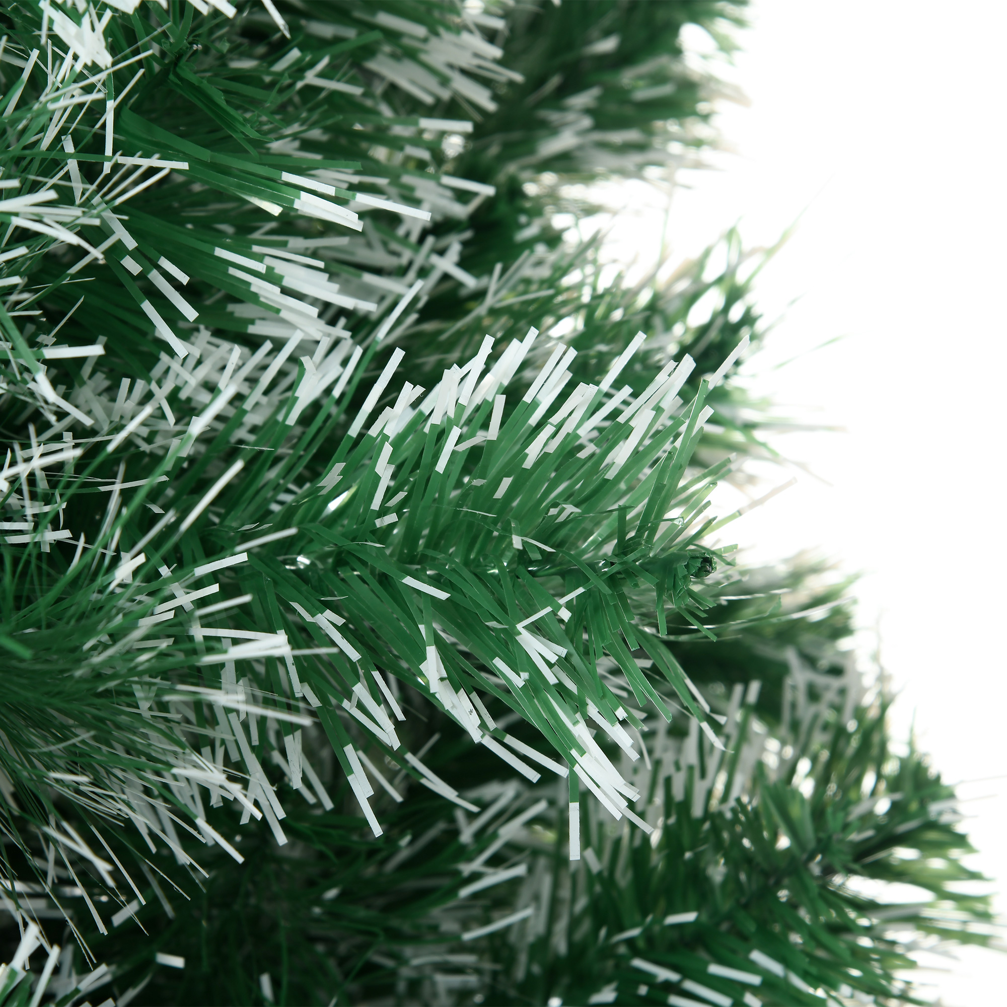 Nahaufnahme von grünen Weihnachtsbaumzweigen mit weißen, flauschigen Akzenten.