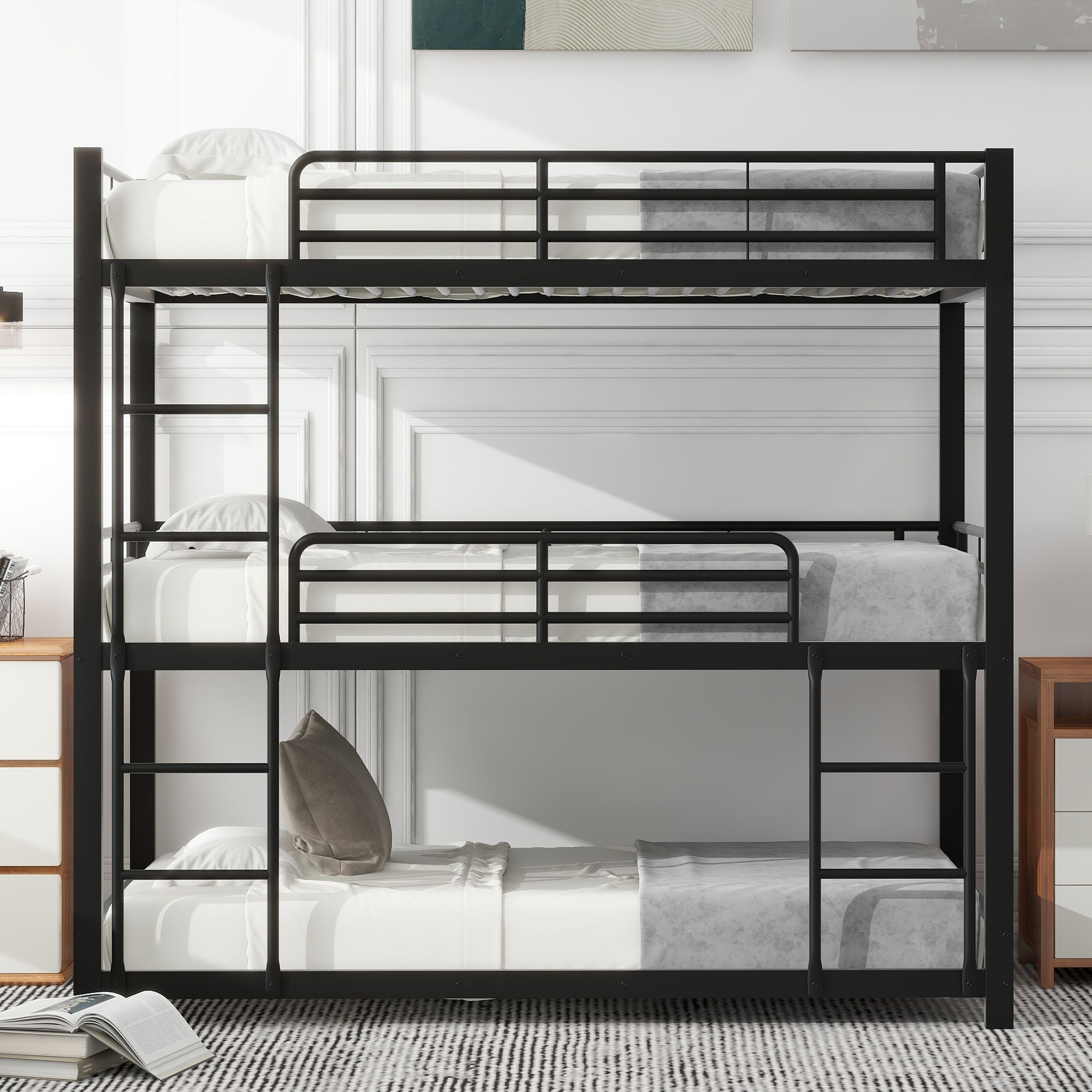 Ein schwarzes Metall-Dreifach-Etagenbett in einem Zimmer. Das Bett hat Matratzen und Kissen. Der Raum hat eine weiße Wand.