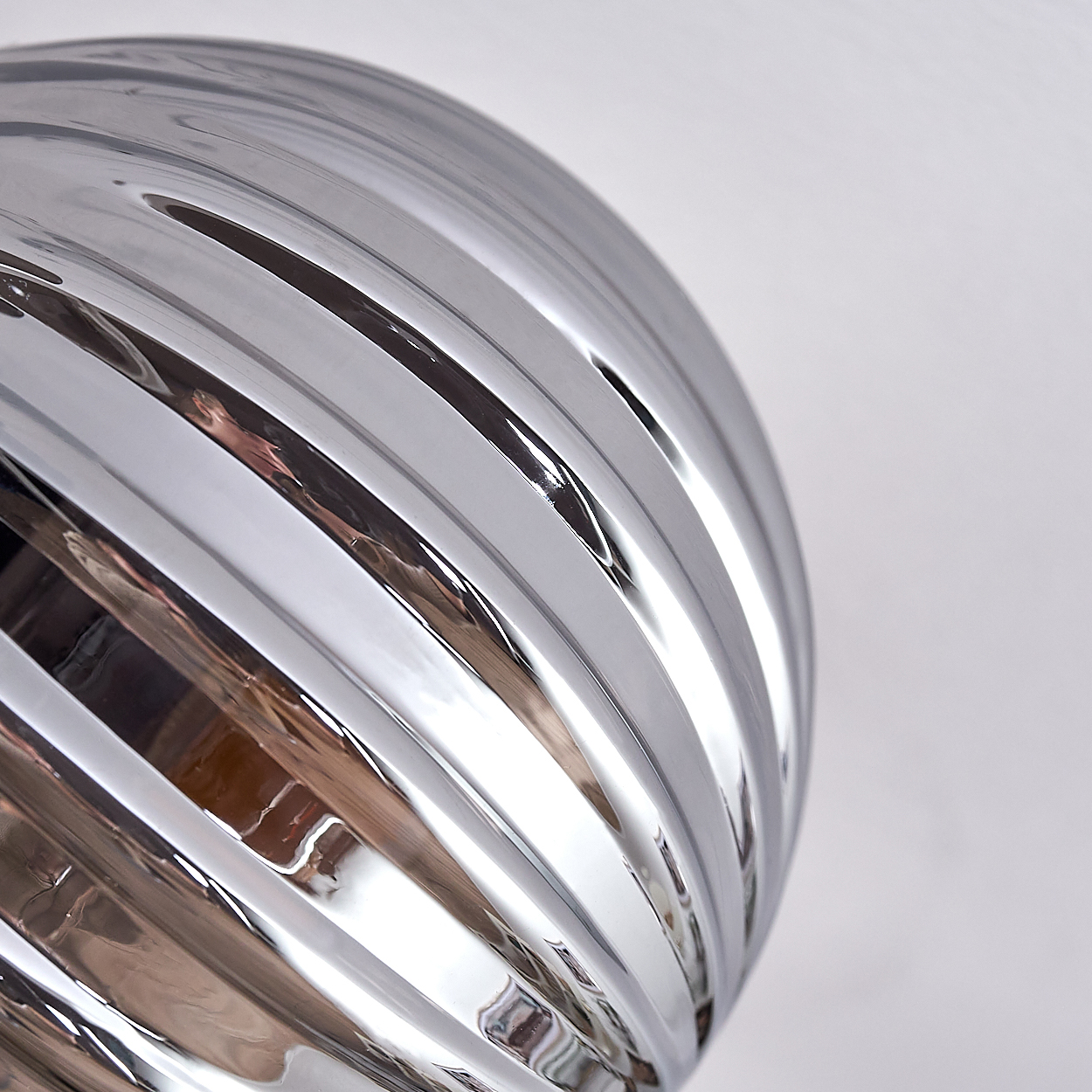 Nahaufnahme eines Teils einer Lampe. Die Oberfläche ist geriffelt und reflektierend.