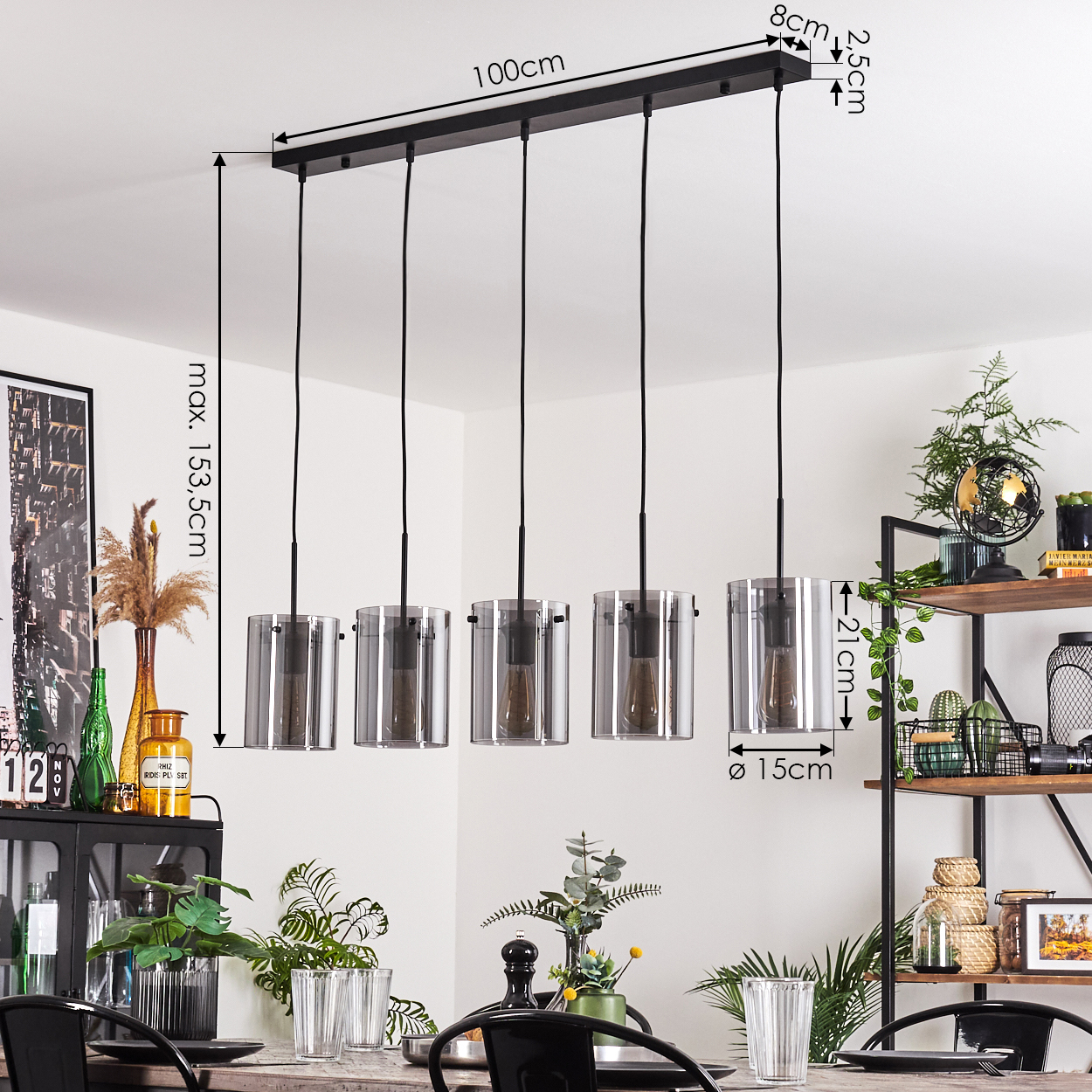 Eine Fünf-Licht-Pendelleuchte mit klaren Glasschirmen hängt über einem Esstisch.