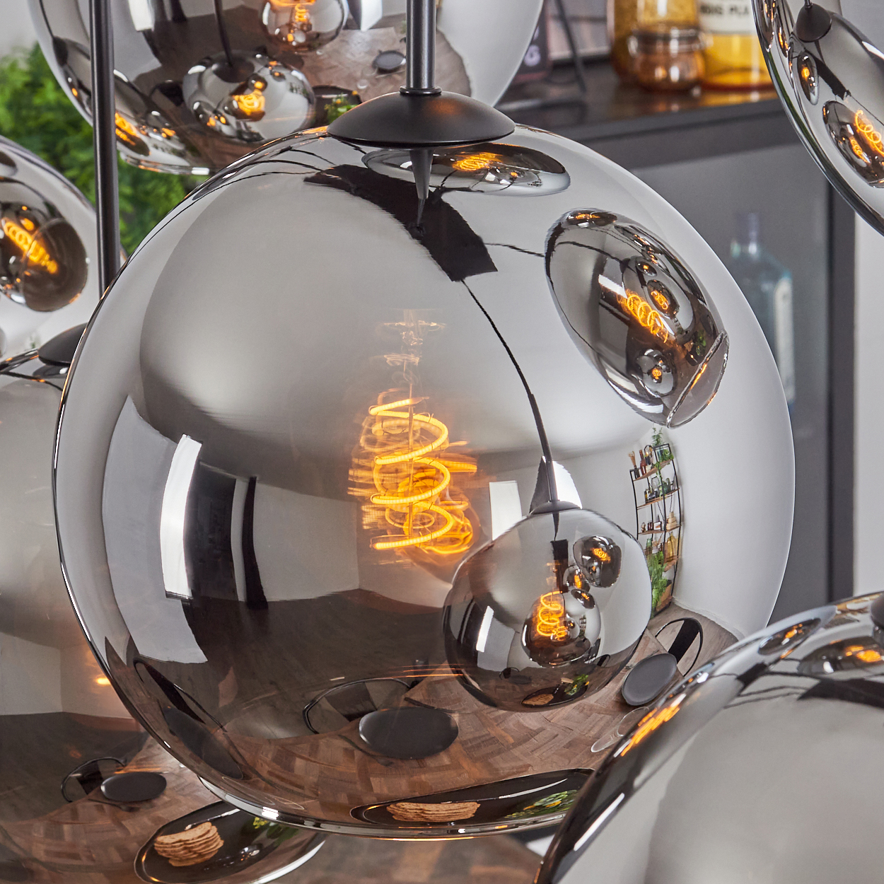 Glänzende, kugelförmige Lampen, die das Innere eines Raumes reflektieren, mit einer Wendelglühbirne im Inneren.