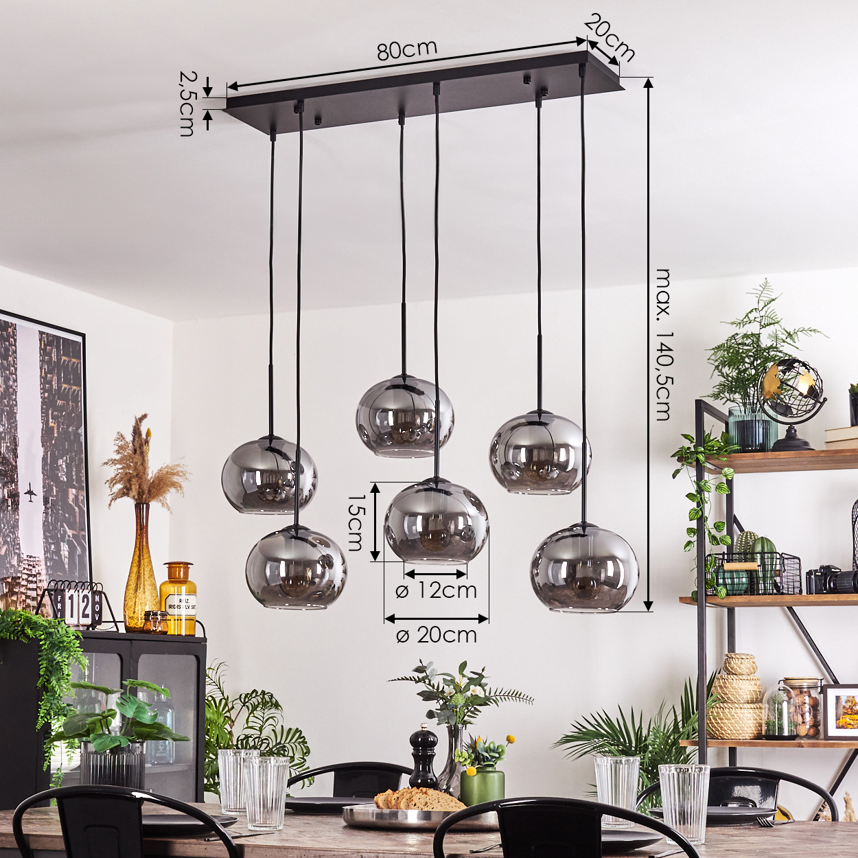 Ein Esszimmer mit sechs hängenden grauen Kugelleuchten über einem Holztisch, Pflanzen und Maße im Hintergrund.