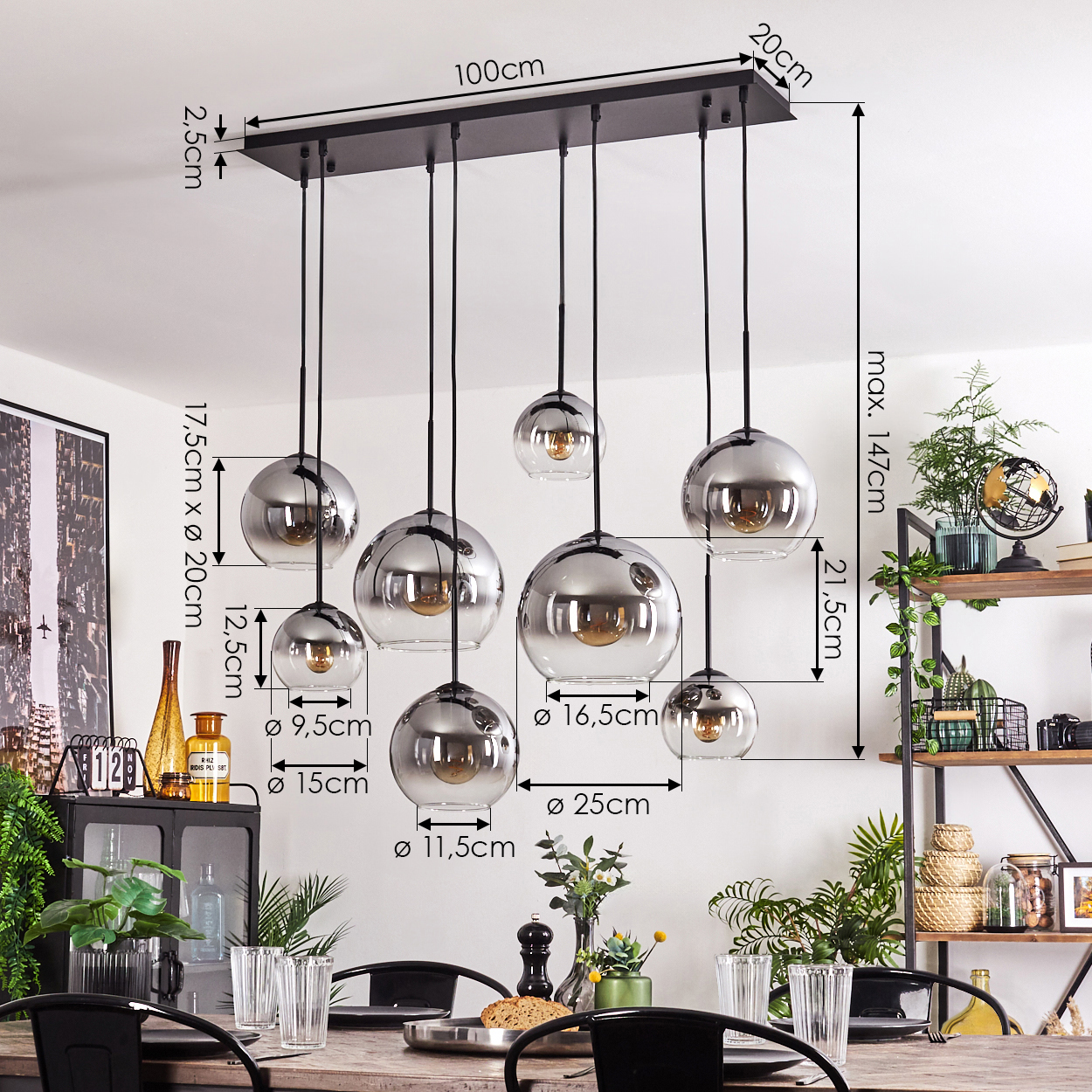 Ein Kronleuchter mit mehreren silbernen Kugelleuchten, Maße beschriftet, in einem Esszimmer mit Tisch und Dekoration.