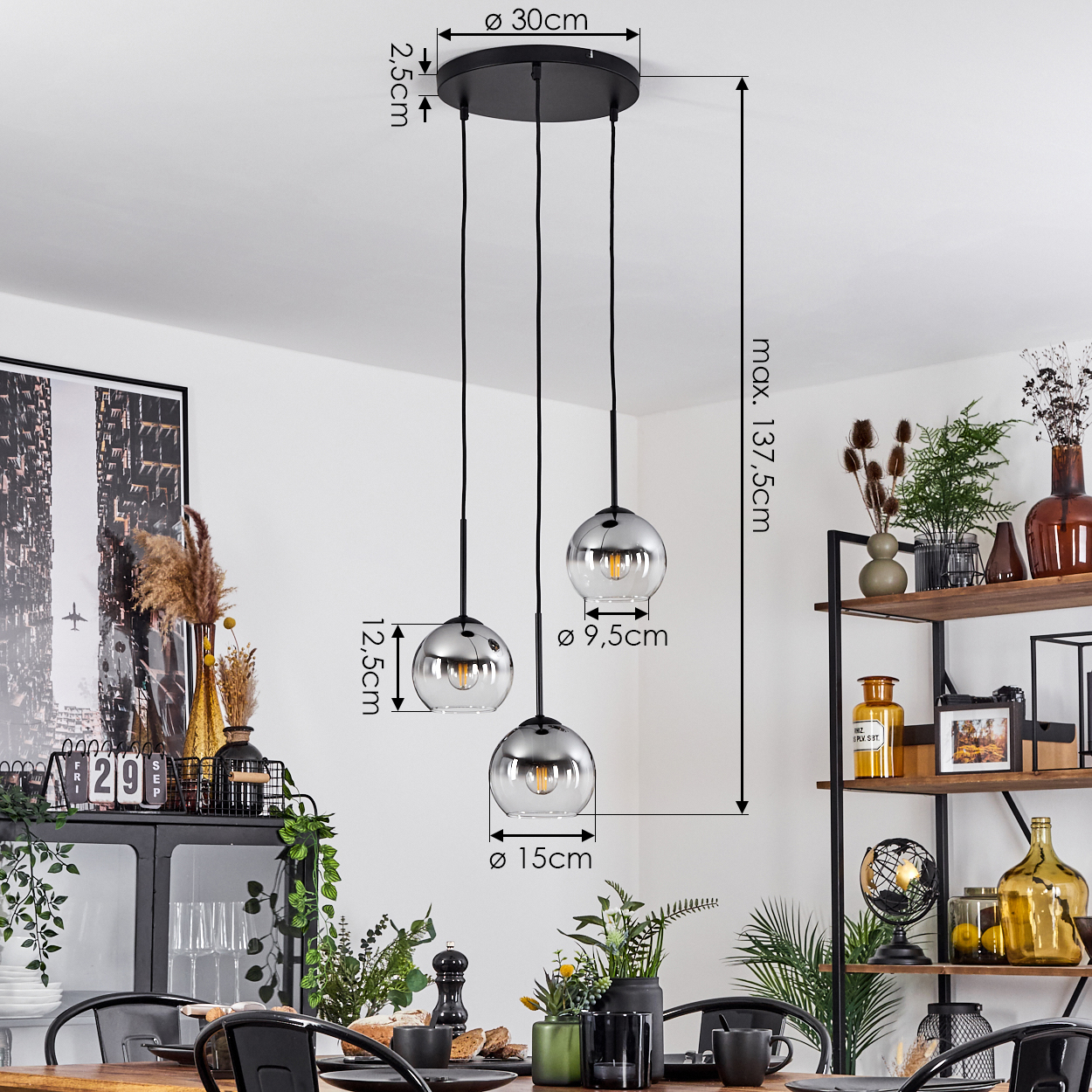 Esszimmer mit drei Glaskugel-Pendelleuchten. Tisch mit Brot, Pflanzen und Dekoration.