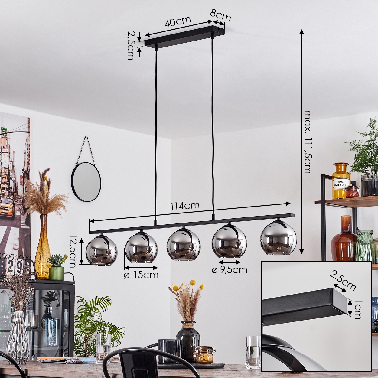 Eine Hängelampe mit fünf silbernen Kugelleuchten. Die Lampe hängt über einem Holztisch. Maße sind im Bild enthalten.