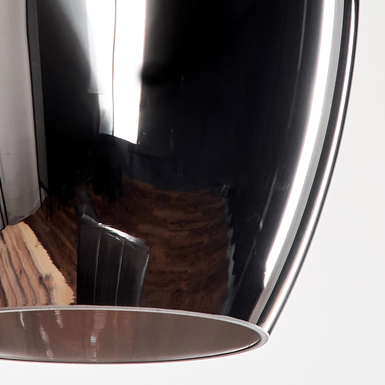 Nahaufnahme des Glases einer Pendelleuchte. Spiegelähnliche Reflexion. Licht am Boden. Holzfußbodenreflexion.
