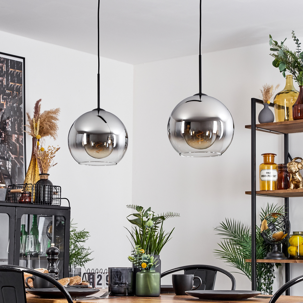 Zwei hängende Pendelleuchten mit verspiegeltem Glaskugel-Design in einem dekorierten Raum.