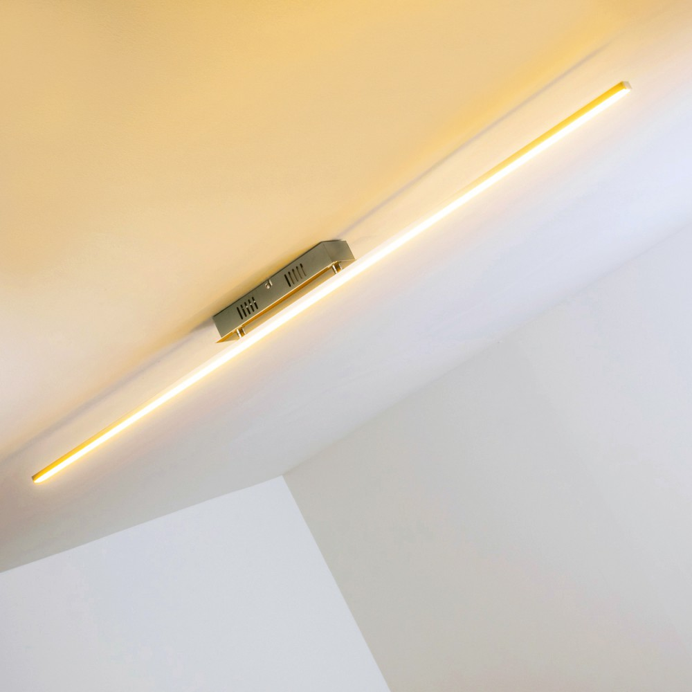 Eine Deckenleuchte mit einem langen, hellen Lichtbalken. Der Hintergrund ist eine weiße Decke und Wand.