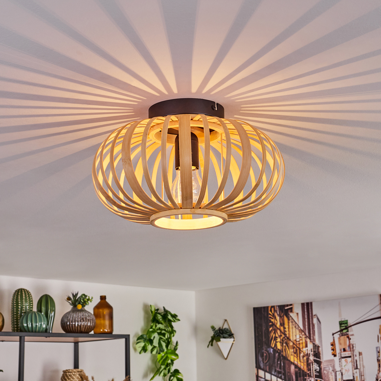 Eine Deckenlampe im Bambus-Stil wirft Lichtmuster auf die Decke. Die Lampe ist beleuchtet.