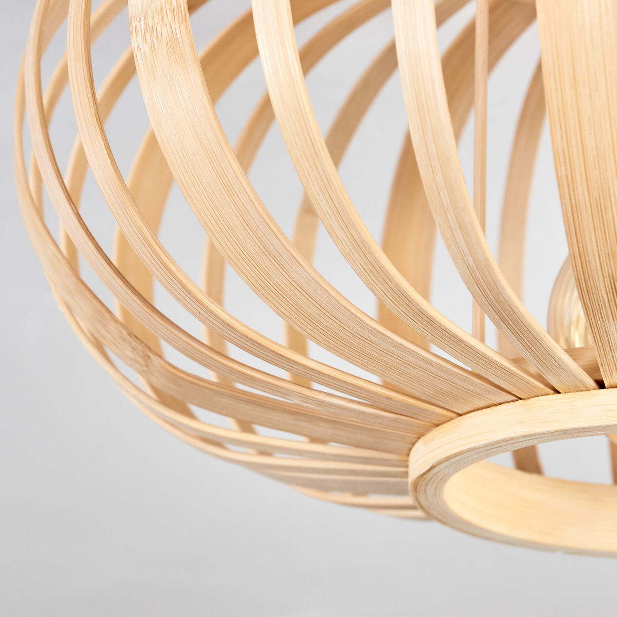 Nahaufnahme des Designs einer Deckenlampe aus Holz. Zeigt den Holzrahmen und die Lichtquelle im Inneren.