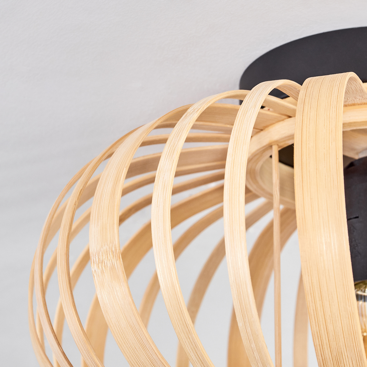 Nahaufnahme einer Deckenlampe im Bambus-Stil mit offenem Design und sichtbarer Glühbirne.