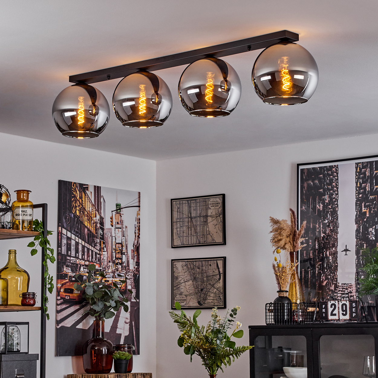 Eine Decke mit vier Hängelampen. Die Lampen haben eine Chromoberfläche und sind beleuchtet. Esszimmer mit Dekoration.