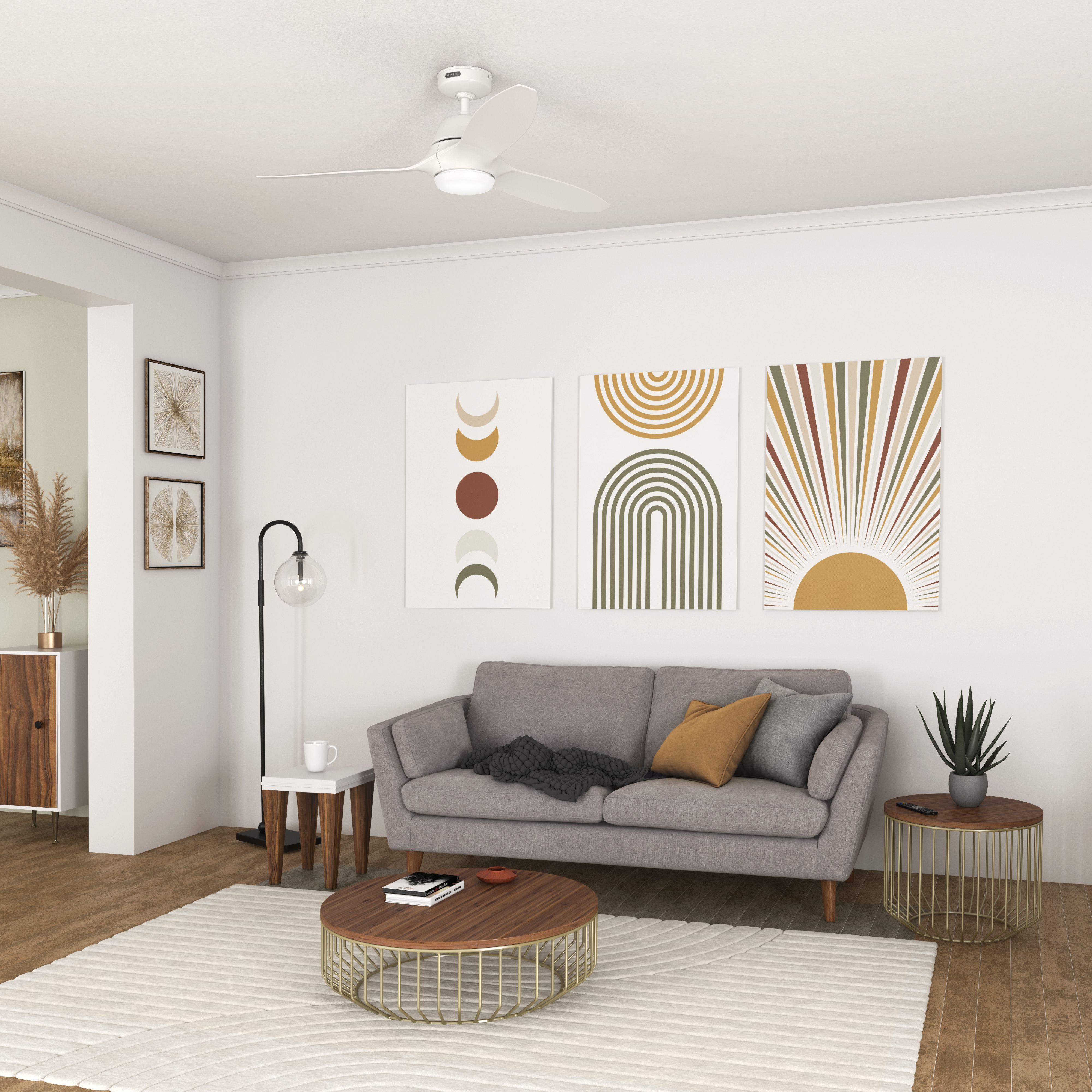 Ein Wohnzimmer mit einem grauen Sofa, einem Couchtisch, Kunst und einem weißen Deckenventilator. Der Stil ist modern.
