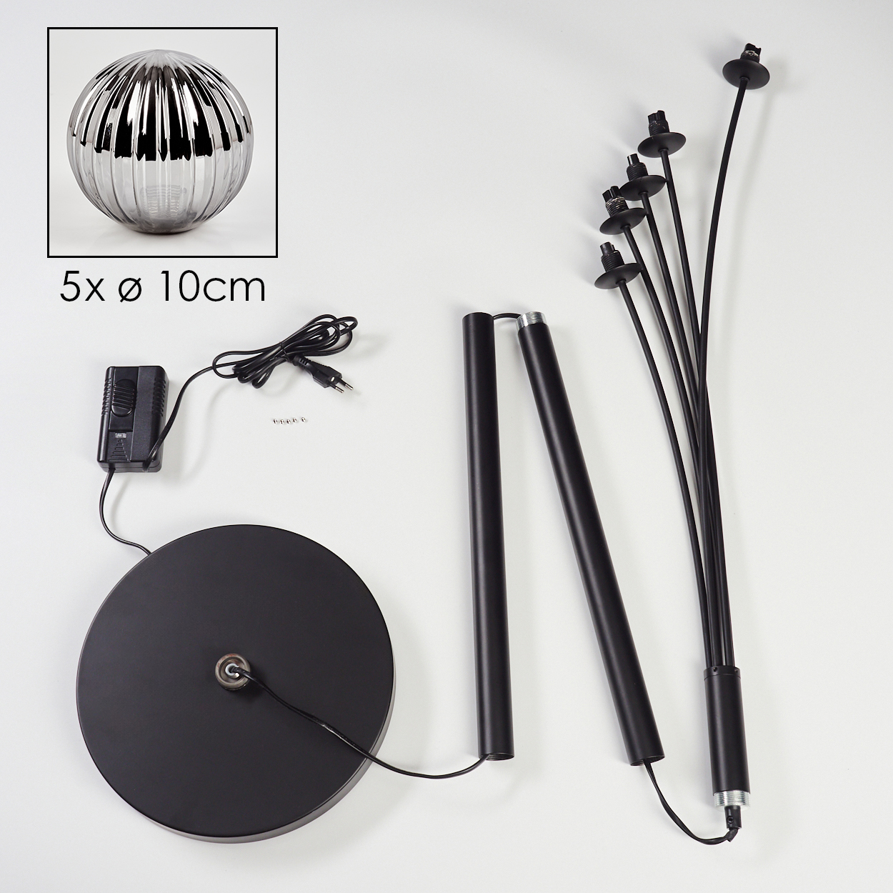 Draufsicht einer zerlegten Lampe mit silberner Kugel, schwarzem Sockel und langen Stielen.