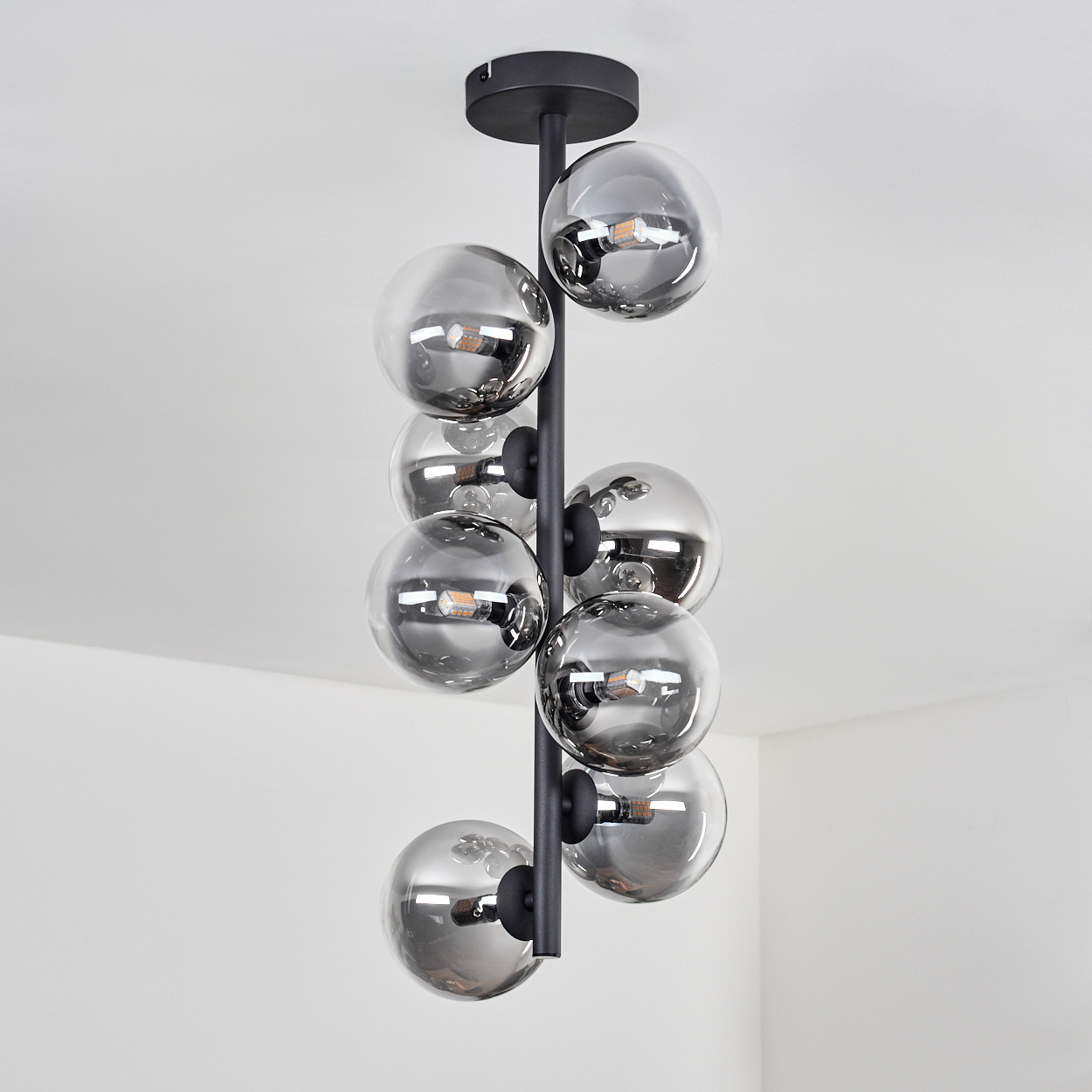 Eine schwarze Deckenlampe mit neun kugelförmigen, reflektierenden Glaskolben.