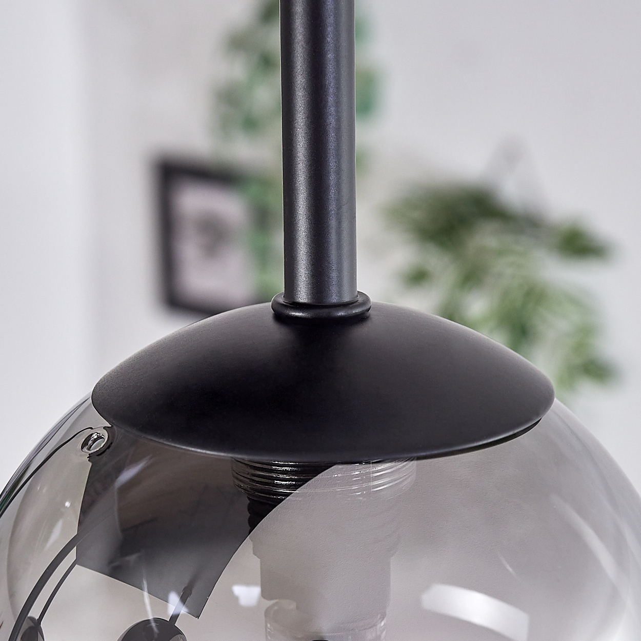 Nahaufnahme einer Leuchte mit schwarzem Stiel und einer reflektierenden Glaskugel.