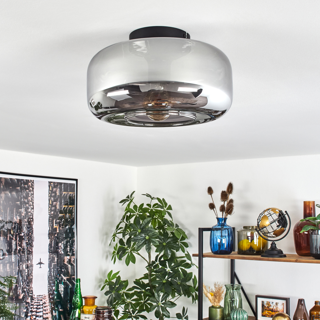 Eine Deckenlampe mit rundem, reflektierendem Glasschirm; Innenraum mit Glühbirne, Raumbild.