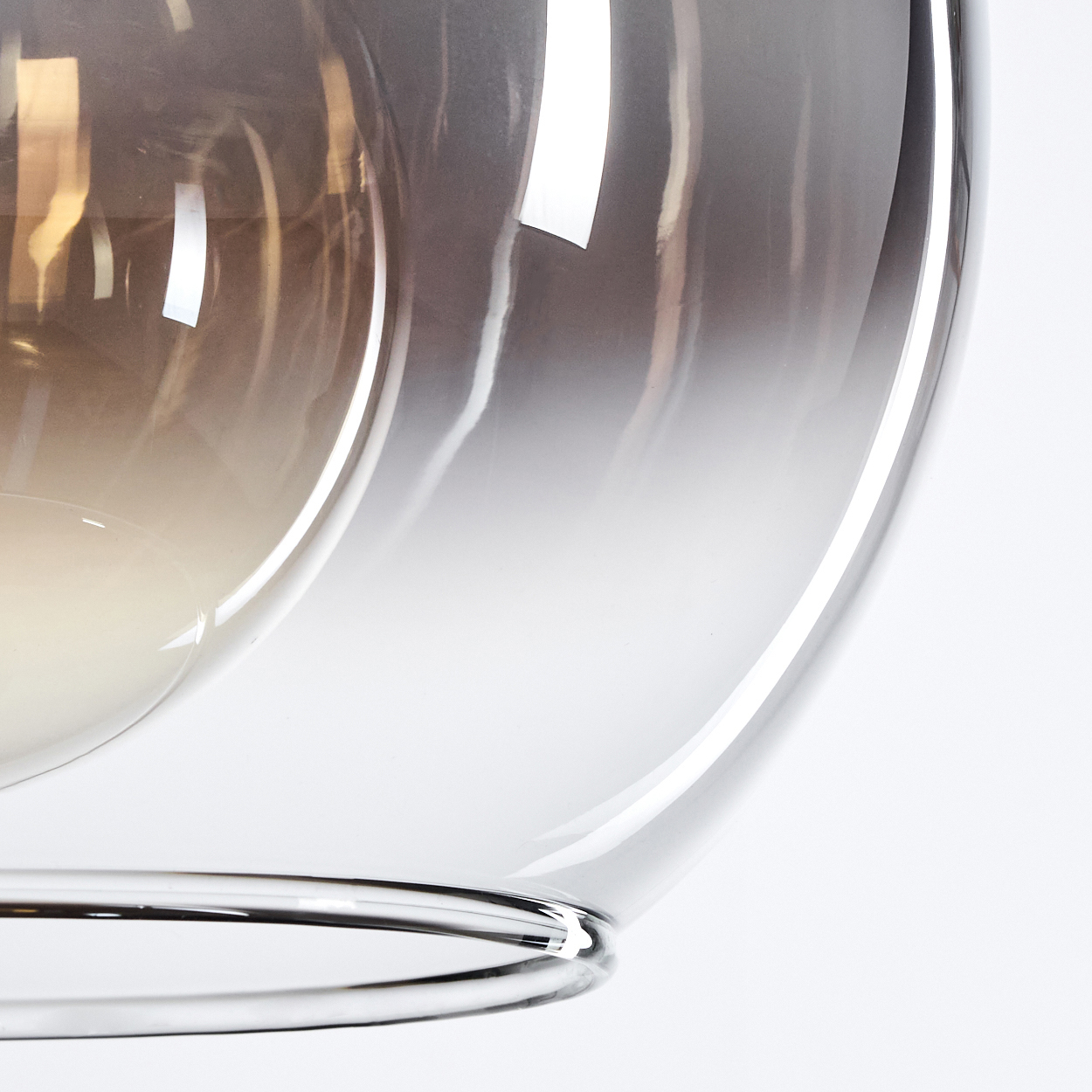 Nahaufnahme einer Glaskugel mit Farbverlaufseffekt. Das Glas hat eine glatte, reflektierende Oberfläche.