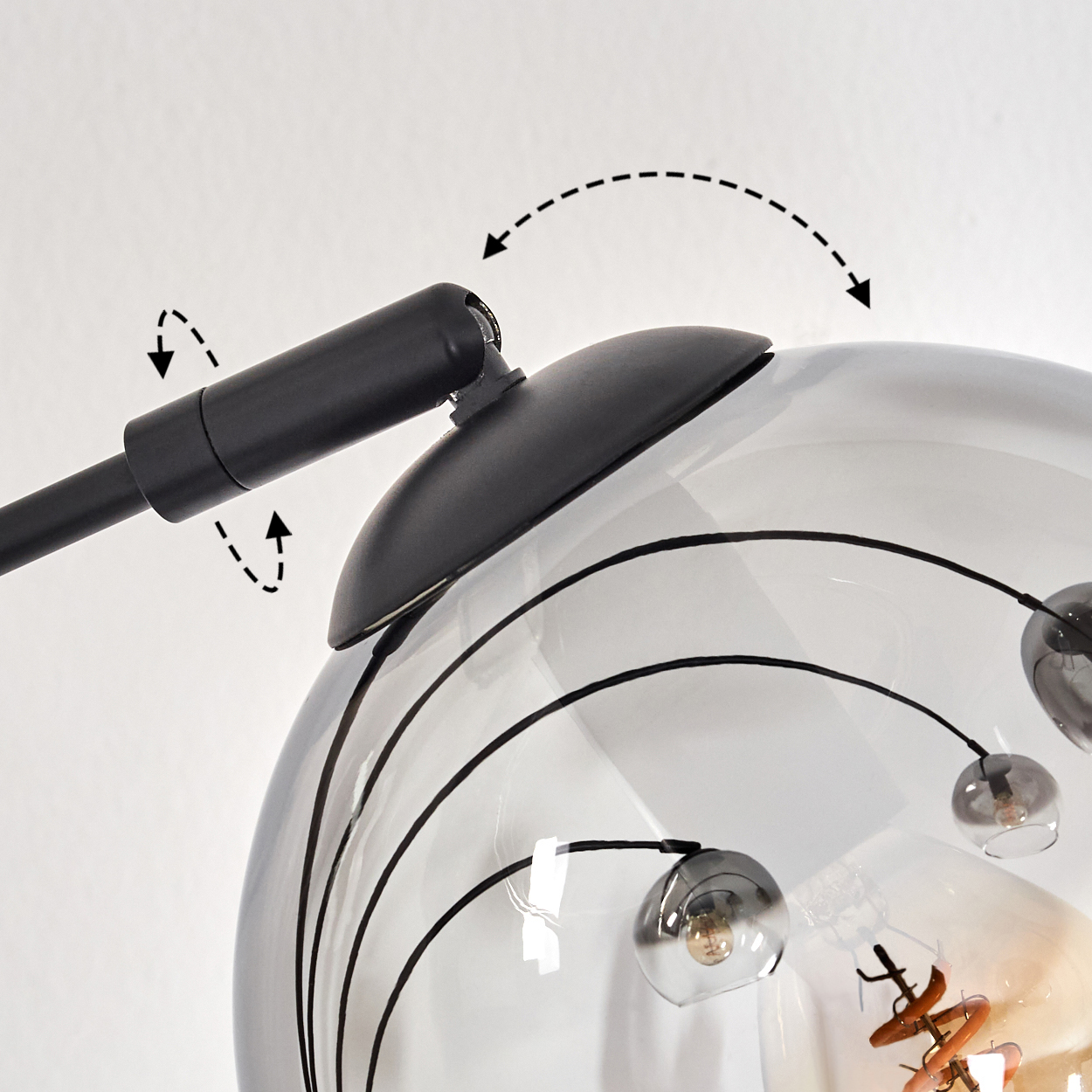 Nahaufnahme einer Lampe mit gebogenen Armen und Glaskugeln. Das Bild zeigt die möglichen Einstellungen der Lampe.